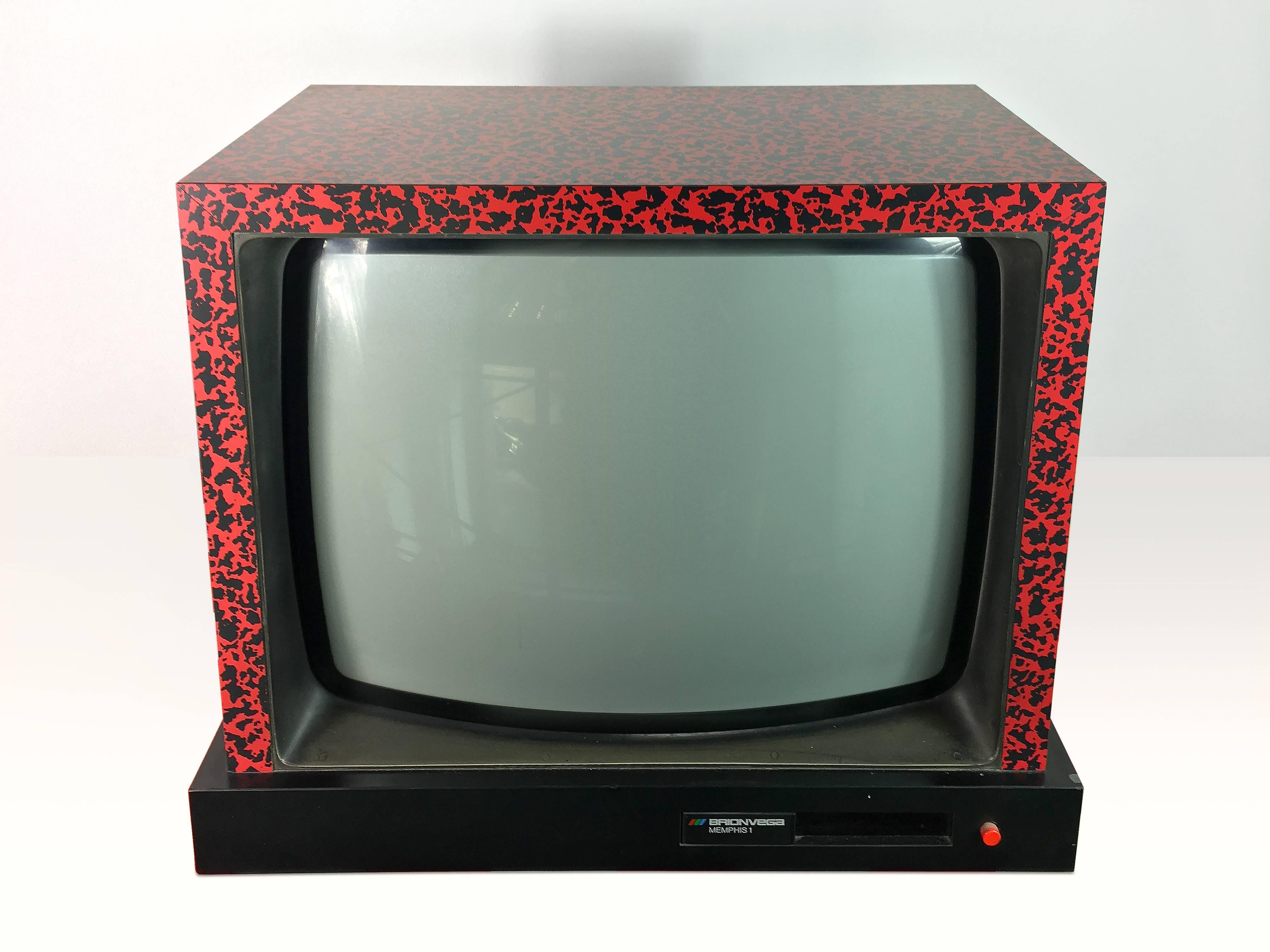 Big tube TV designed by Ettore Sottsass and Matteo Thun as part of Studio Memphis for Brionvega. TV is covered with red patterned laminated plastic.