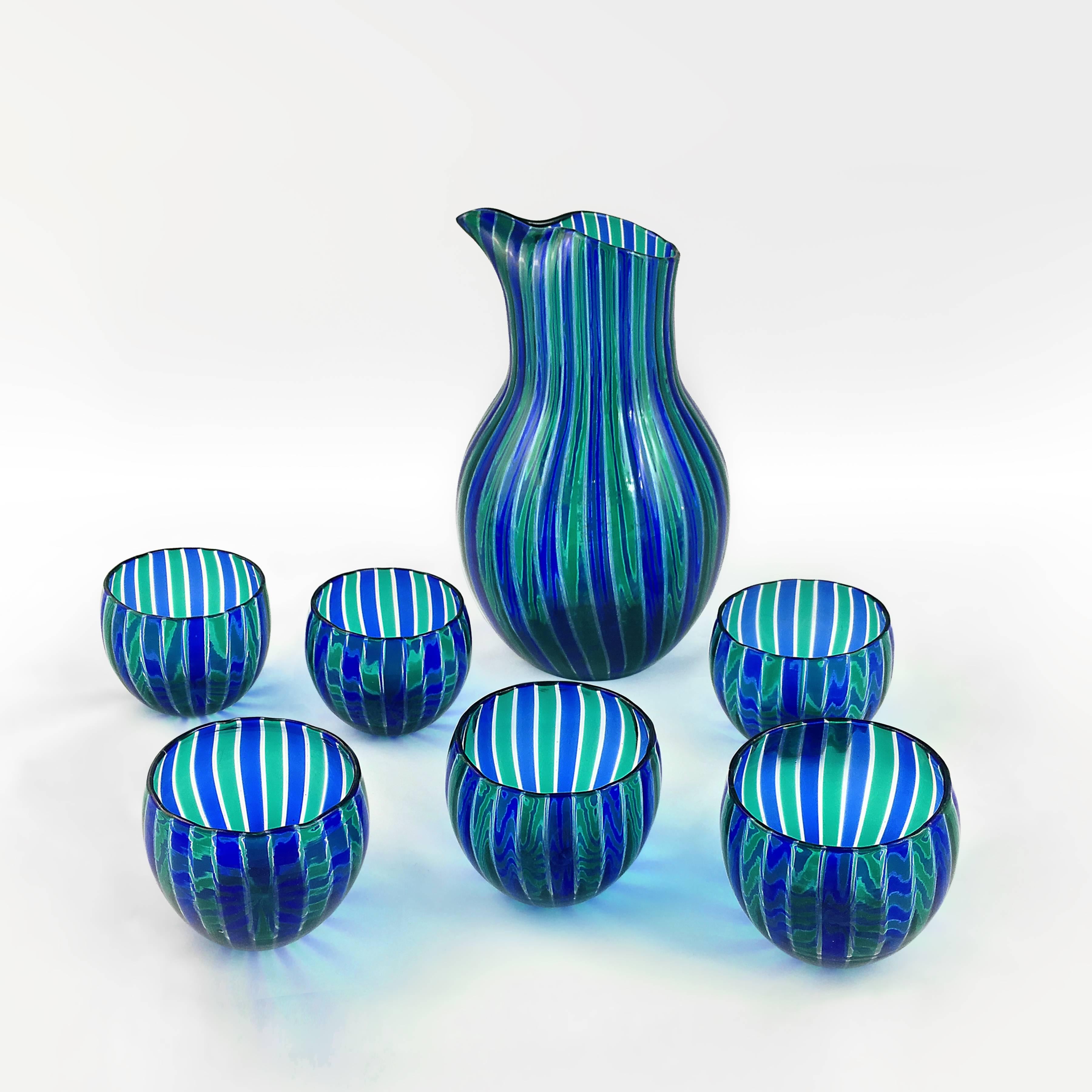 Blue-green striped set of jar and six glasses designed by Gio Ponti for Venini production.
Measures: Glasses diameter 8cm.
