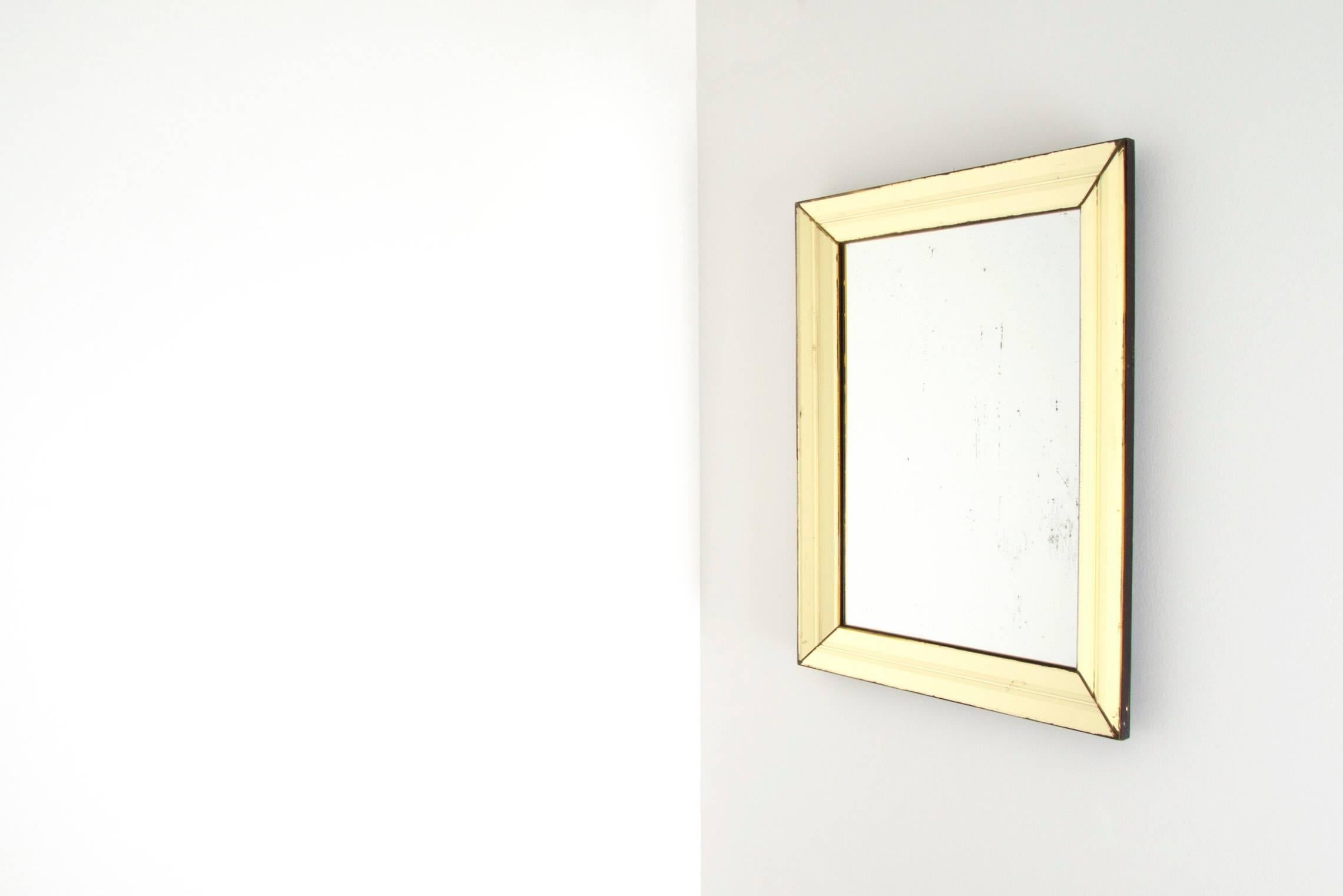 Fontana Arte, yellow glass mirror, circa 1950.
The base of the mirror is in hard wood. The frame is covered in convex with four yellow colored mirrors engraved with straight lines.
Some chips on the yellow glasses. Stain on the mirror. The
