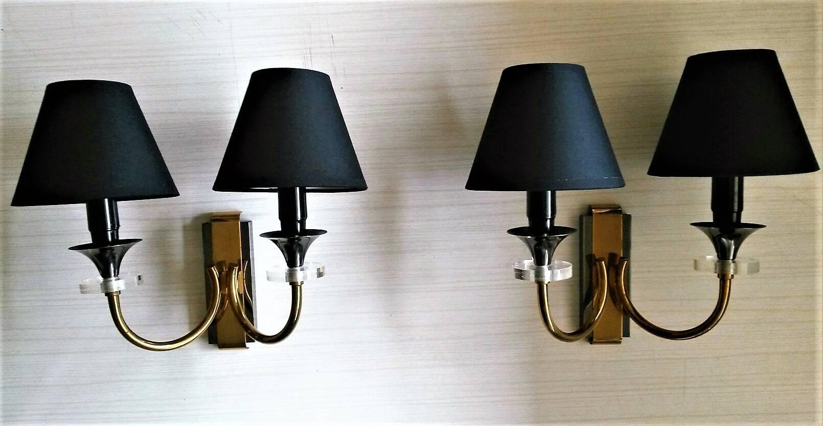 Beautiful pairs of two-arm gilt bronze sconces appliques by Maison Jansen presenting two different patinas in gilt bronze and gun metal and charming details of clear discs of Lucite glass under each cup.
(Making a great rare to find set of four