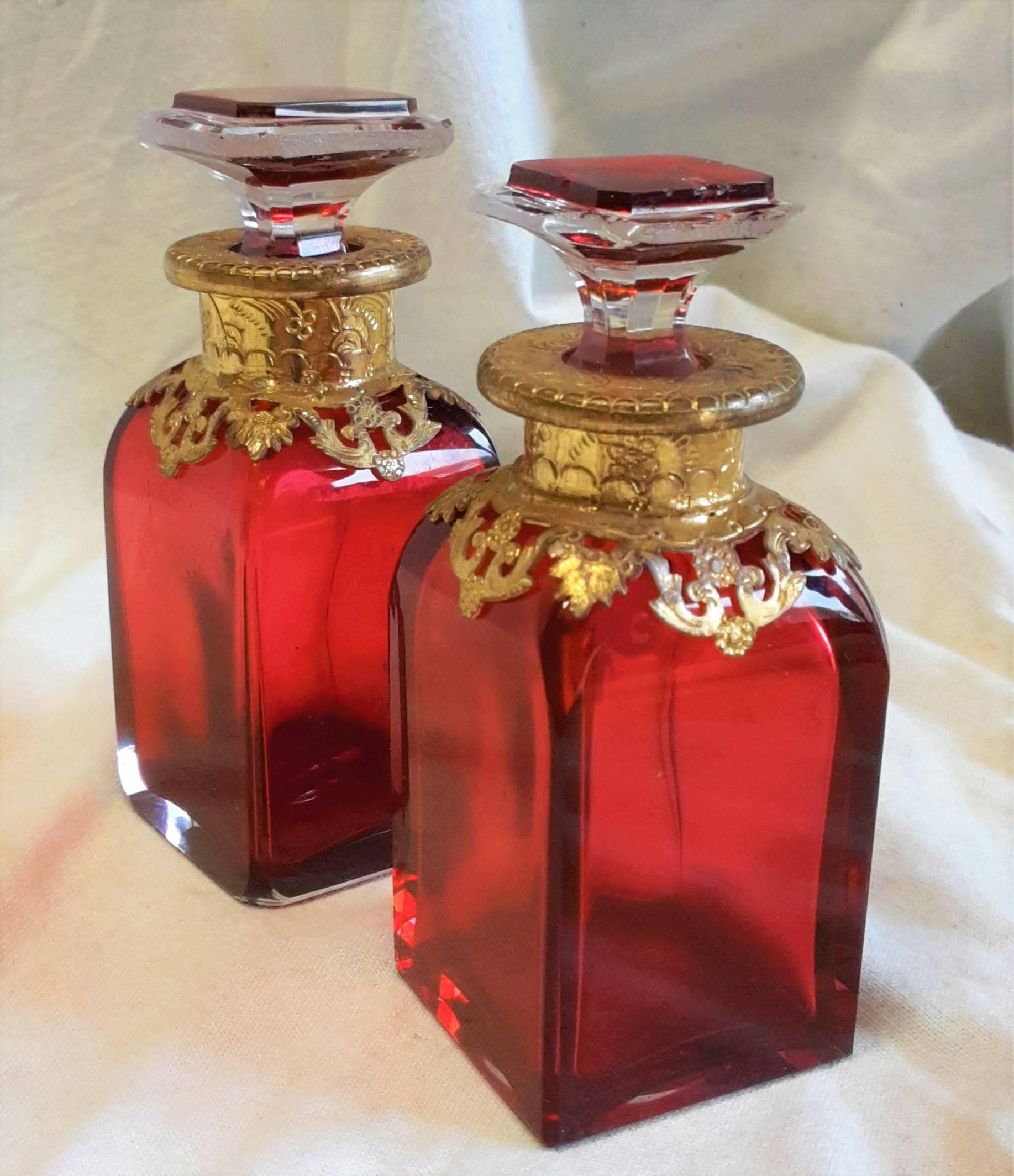 Pair of Napoleon III crystal perfume bottles, the inside and parts of the bottle cap are tinted in red color and decorated with golden brass.
Original, handmade bottles with different details in each one.

France, circa 1870.





 