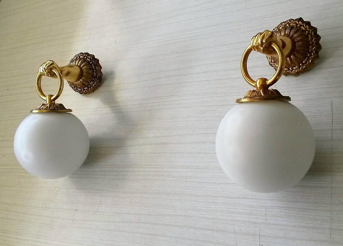 Charming pair of French neoclassical sconces in gilt bronze, in the style of the Maison Jansen. With nice white matte milky opaline globes. The electric part has been renewed, rewired and ready for the US standards (max 40 watts each