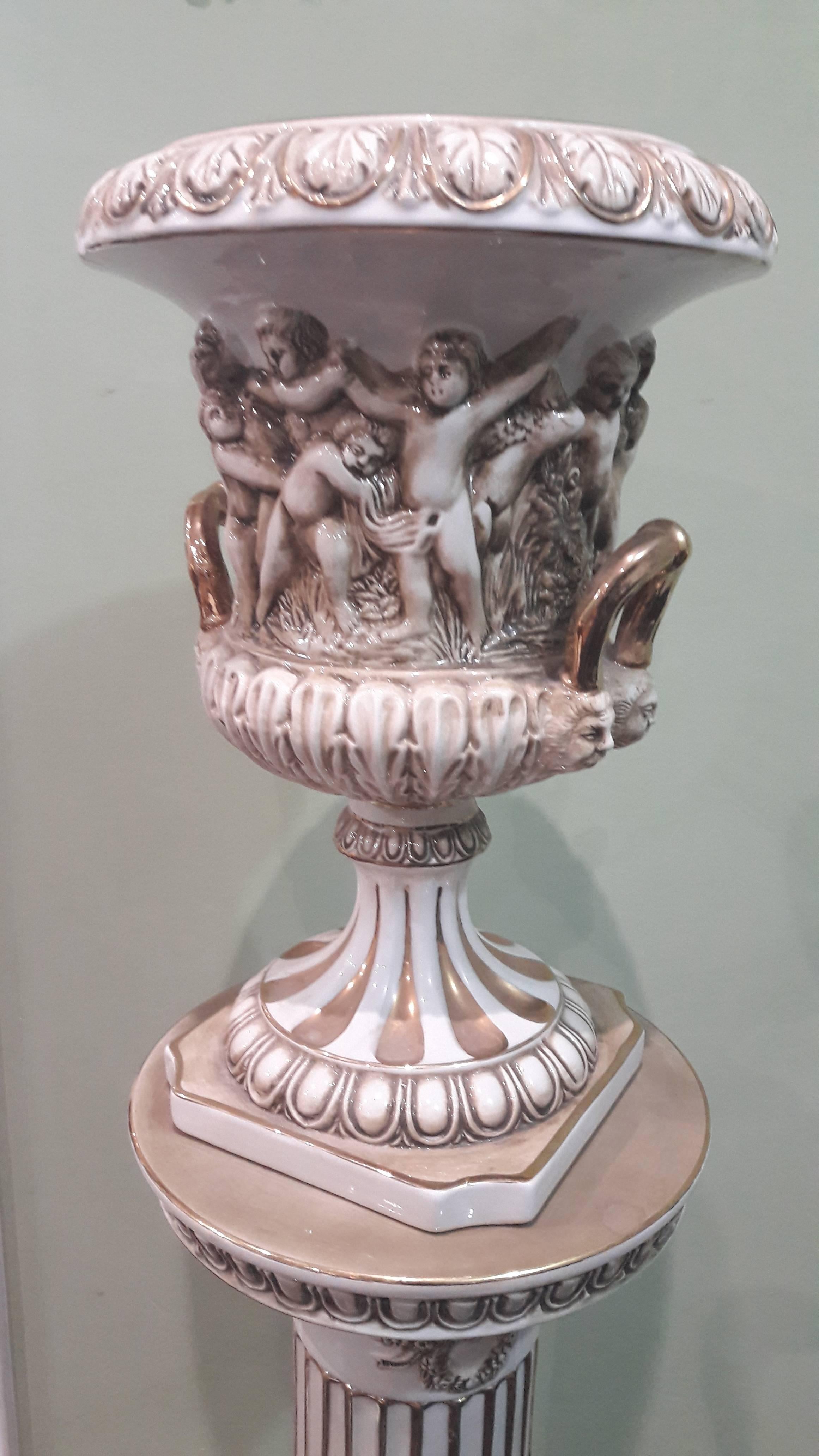 Original Capodimonte porcelain pedestal or column in one piece. And the second part, on the top of it, its Cachepot vase, all beautifully decorated with putti ; ( a tradition for this finest Italian royal porcelain ), and gold handles.
Solid and