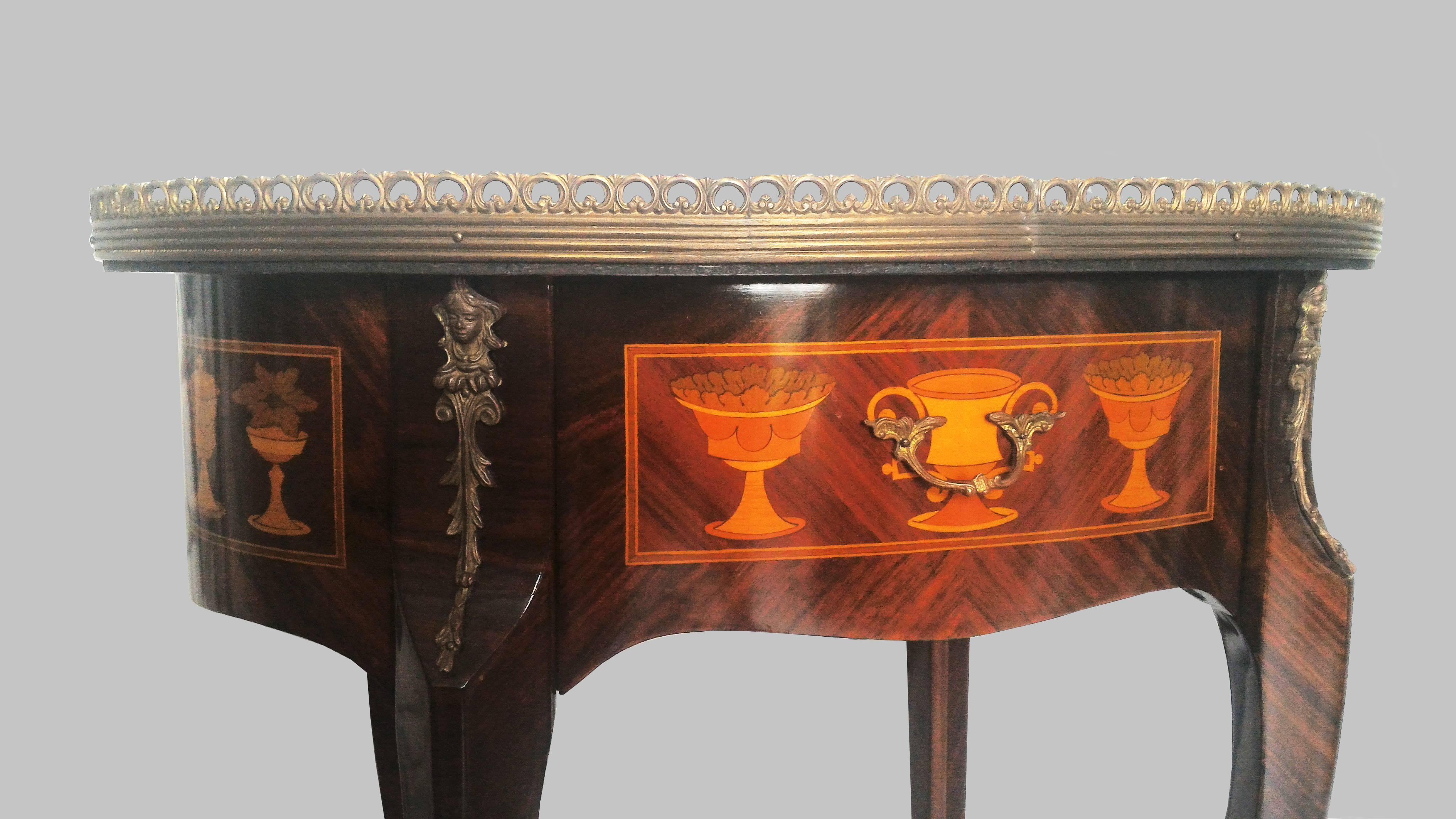 French Gueridon Marquetry side table and gilt bronze and brass ornaments, in oval shape in a beautiful contrast of different wood colors in marquetry, representing classical flowers, leaves, antique vases etc.