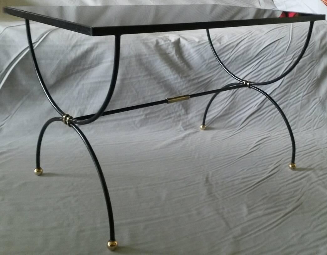 Two beautiful Mid-Century Modern, coffee center tables. 
In blackened lacquered wrought iron and elegant ornementations in gilt bronze. The top black opaline glass is original, France, 1950s.
In a very good condition, a refined table with elegant