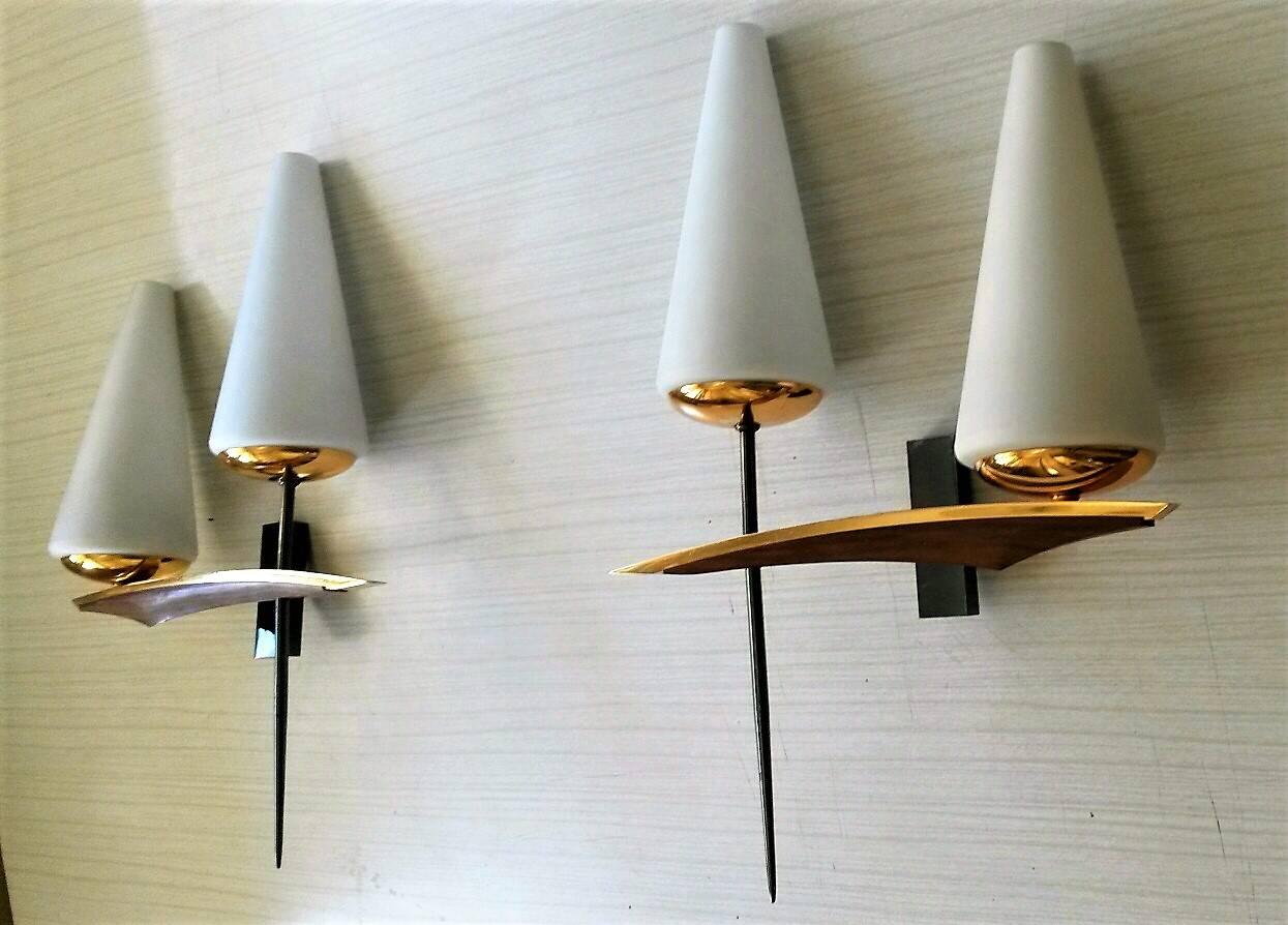 Gorgeous pair of double sconces by Maison Arlus.
Mid-Century Modern style in brass (with special canon de fusil patina), teak wood and satin white opaline glasses, France, 1950s.

Elegant combination of wood, gold and white and asymmetric