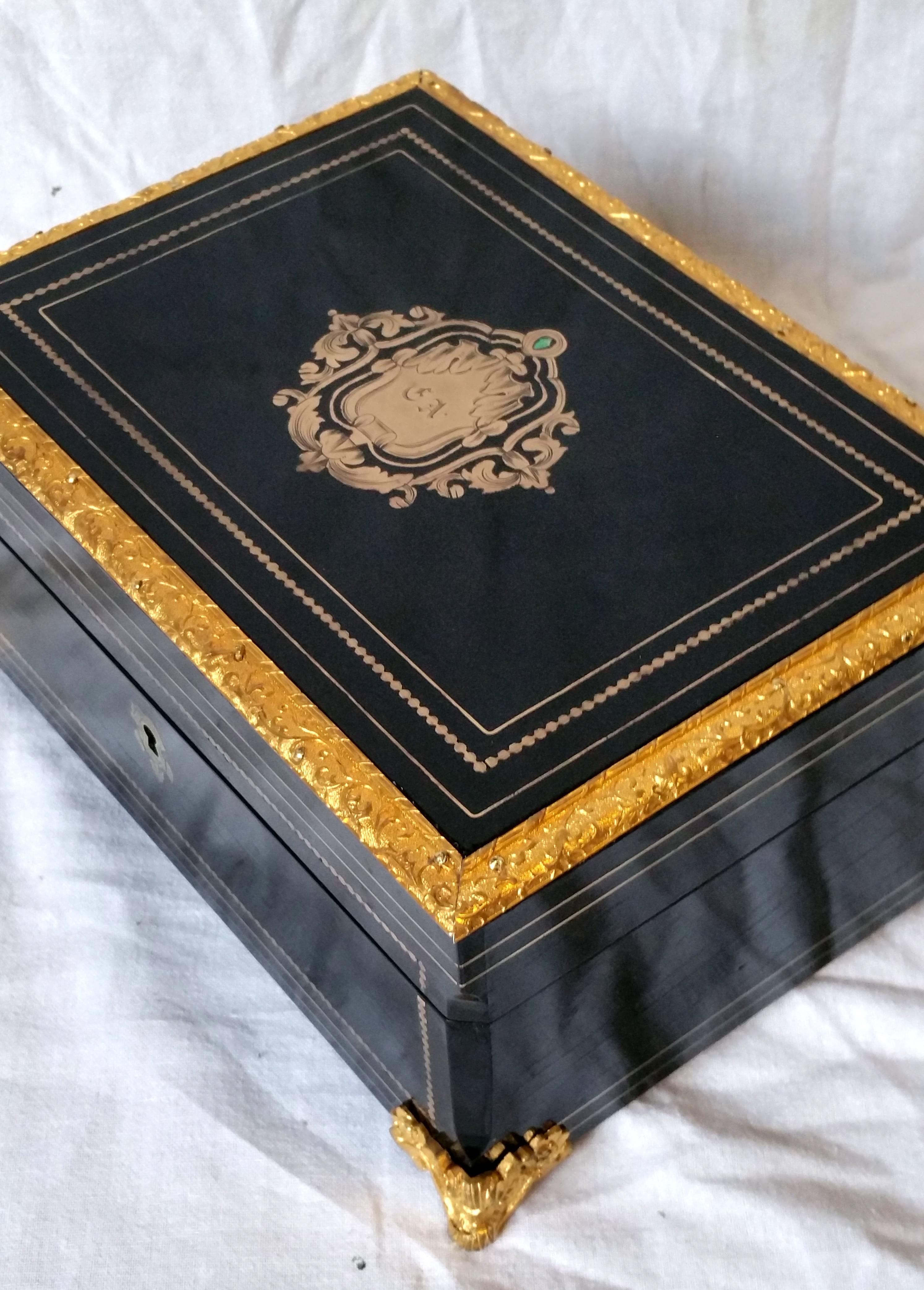 Very chic jewel or decoration box in Boulle style decorated with brass and horn marquetry with splendid gilt bronze ornamentations in its original gilt golden state.
An original pale green floral fabric covers its inner part. 

Totally restored in