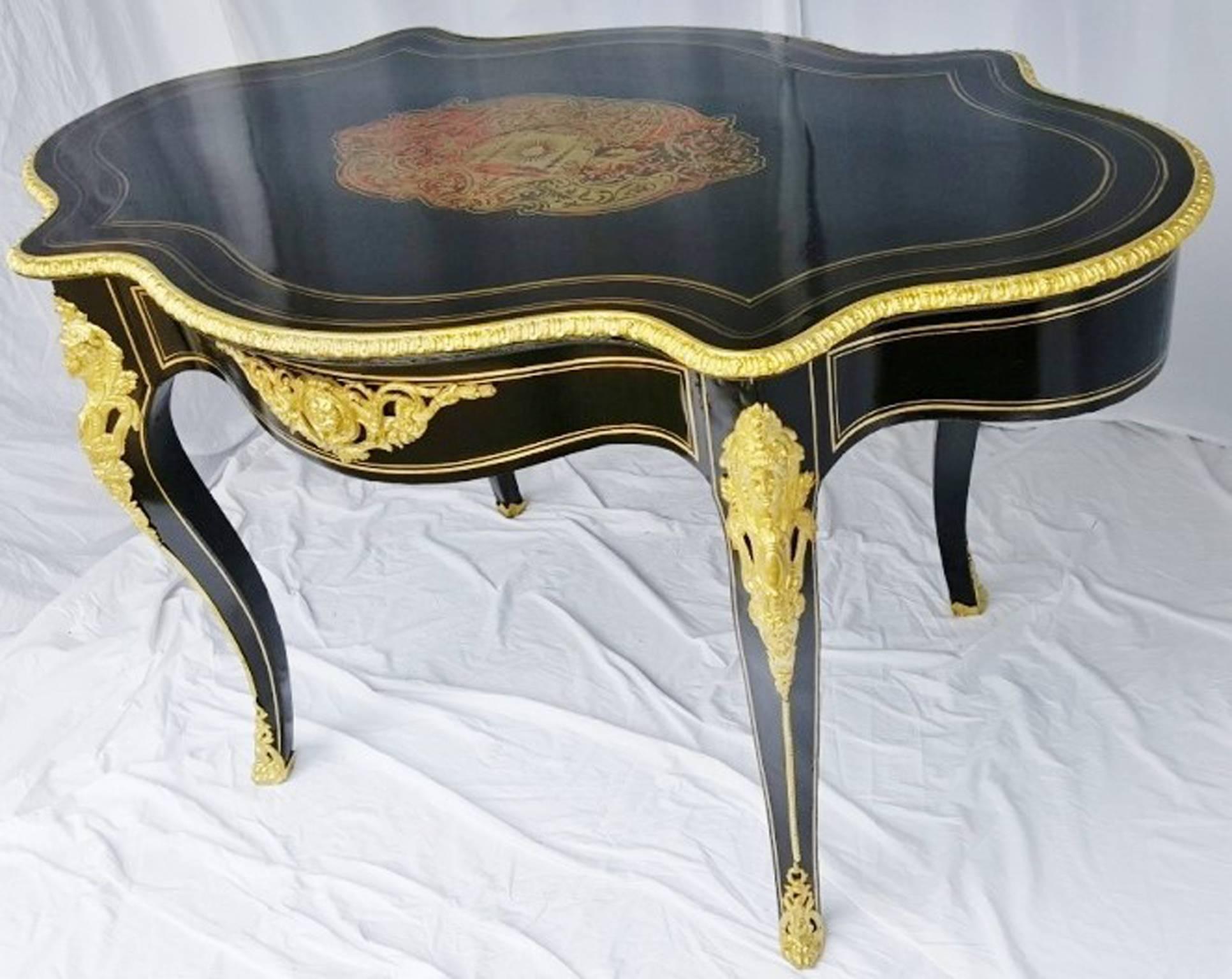 Extremely elegant 19th century French table “Violonée” in Boule marquetry, with beautiful, important gold ornamentations with masks, caryatids, etc.

Entirely restored by our special professionals.

 
