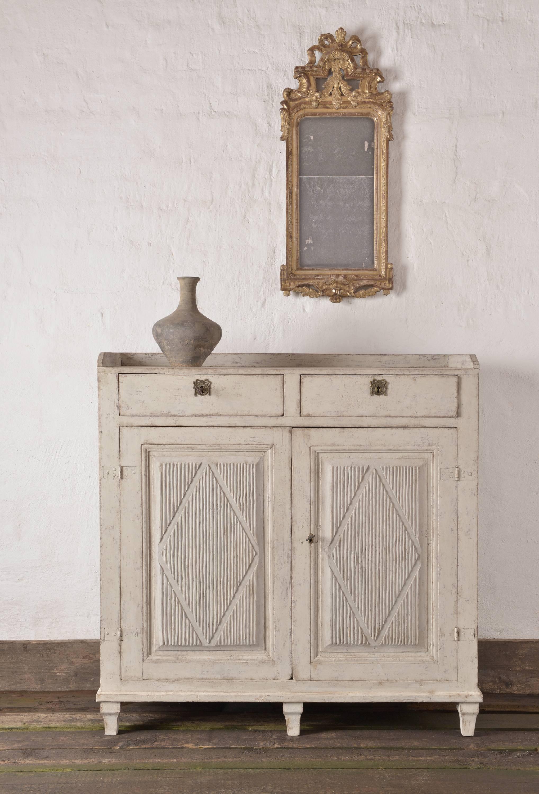 Beautiful Gustavian sideboard from northern Sweden. Reeded fronted doors with harlequin carvings. In northern Sweden the Gustavian Style prevailed well into the 19th century, and this dates to circa 1810-1820. A quintessential Gustavian piece that