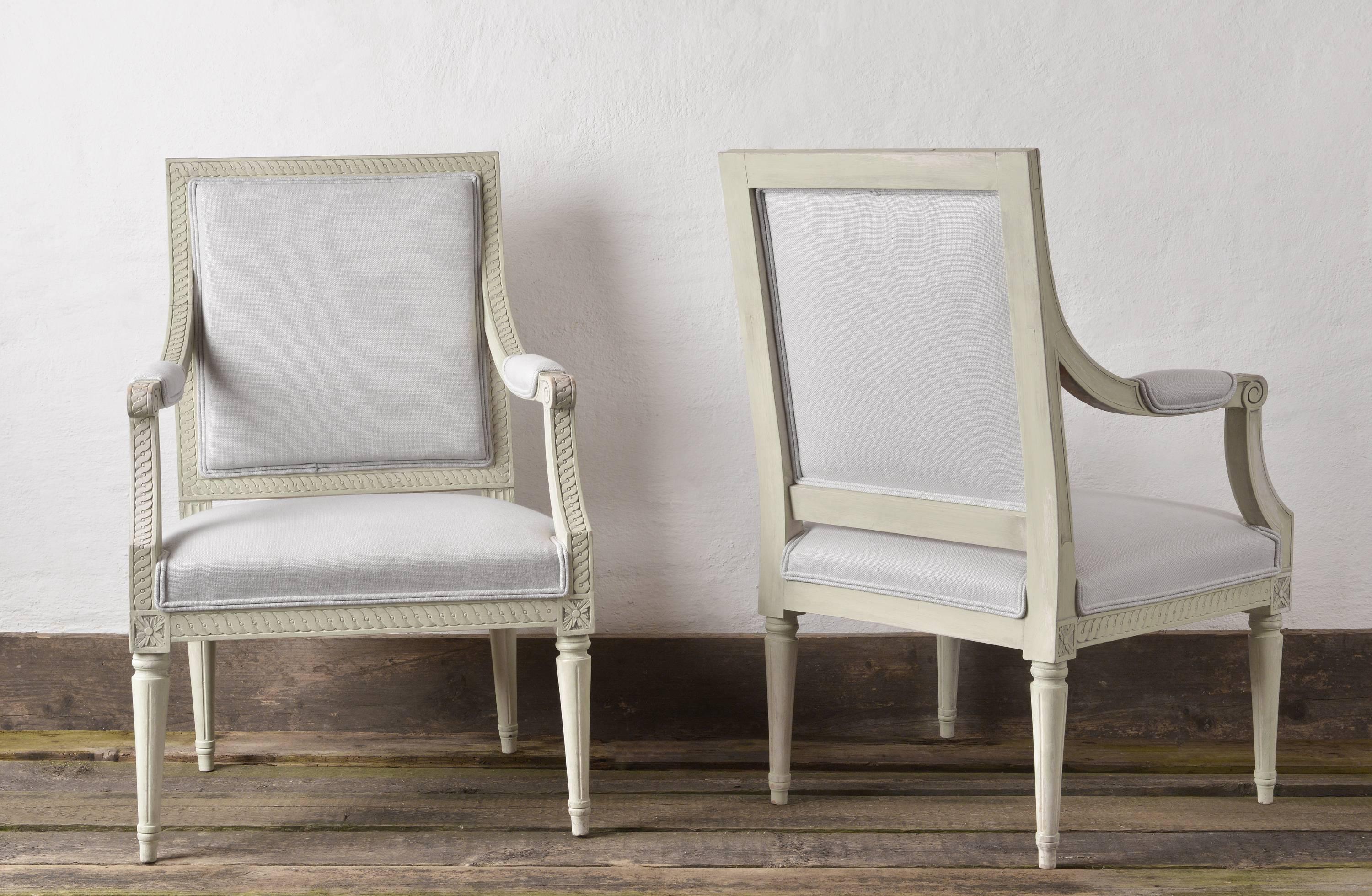 Beautiful large pair of early 20th century Gustavian style Fauteuils a la Reine, the square backrests, armrests and seatrail decorated with a richly carved Guilloche frieze, on fluted legs.
Retouched paint and having recently been recovered in a
