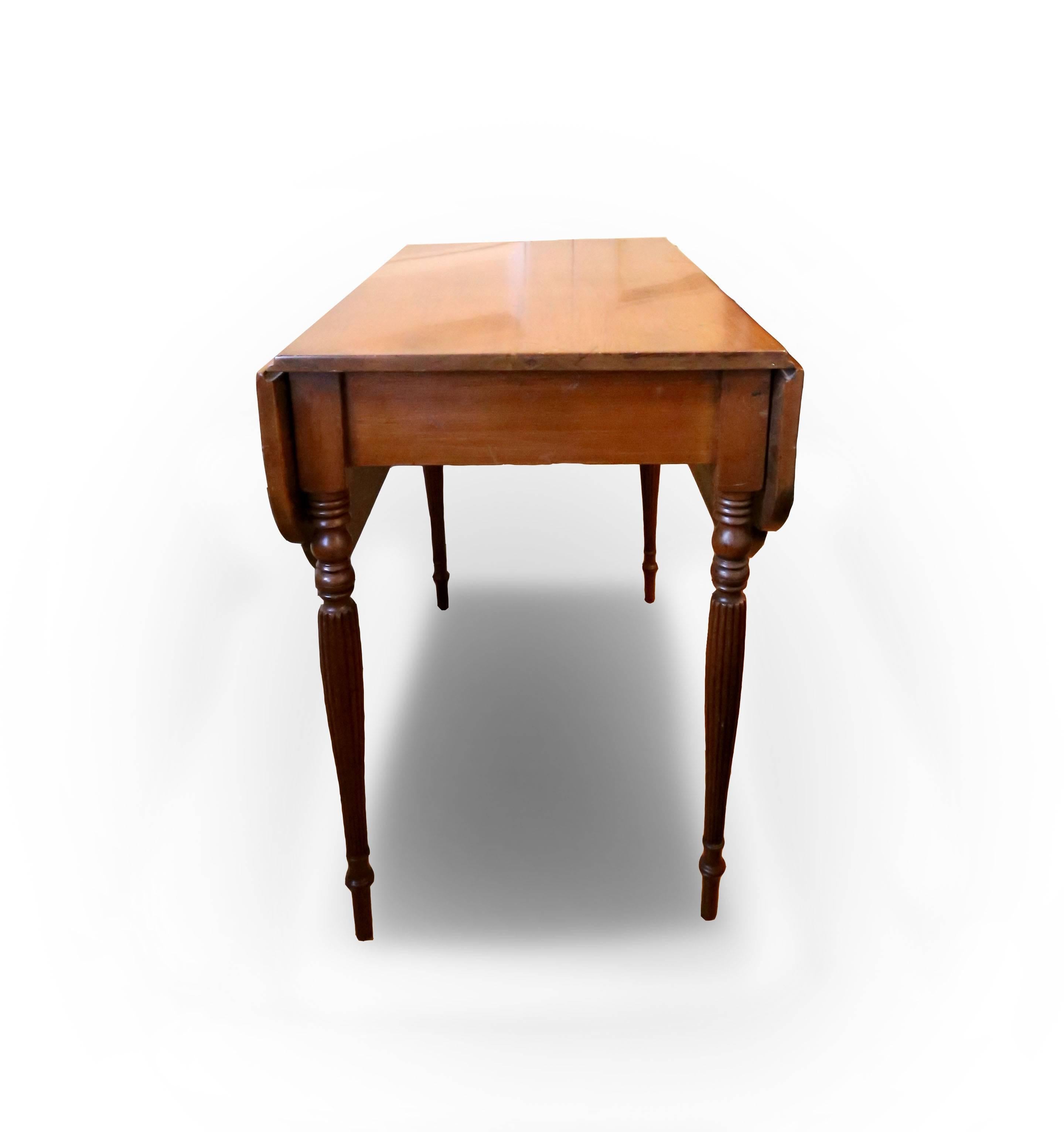 A fine maple drop leaf table of fine proportions, top with cyma corners, legs with delicate reeding. School of Duncan Phyfe, warm light patina. American, New York, circa 1810.