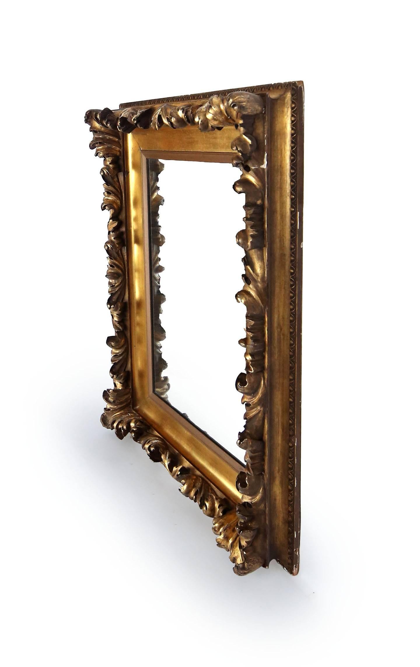 Reich geschnitzter, vergoldeter Spiegel mit Akanthusblättern und klobigem, gadroniertem Rand. Der äußere Rahmen wird durch kleine Ei- und Abnäherleisten eingefasst. Ein Kunstrahmen, der in ein Spiegelglas umgewandelt wurde. Amerikaner, um 1870.