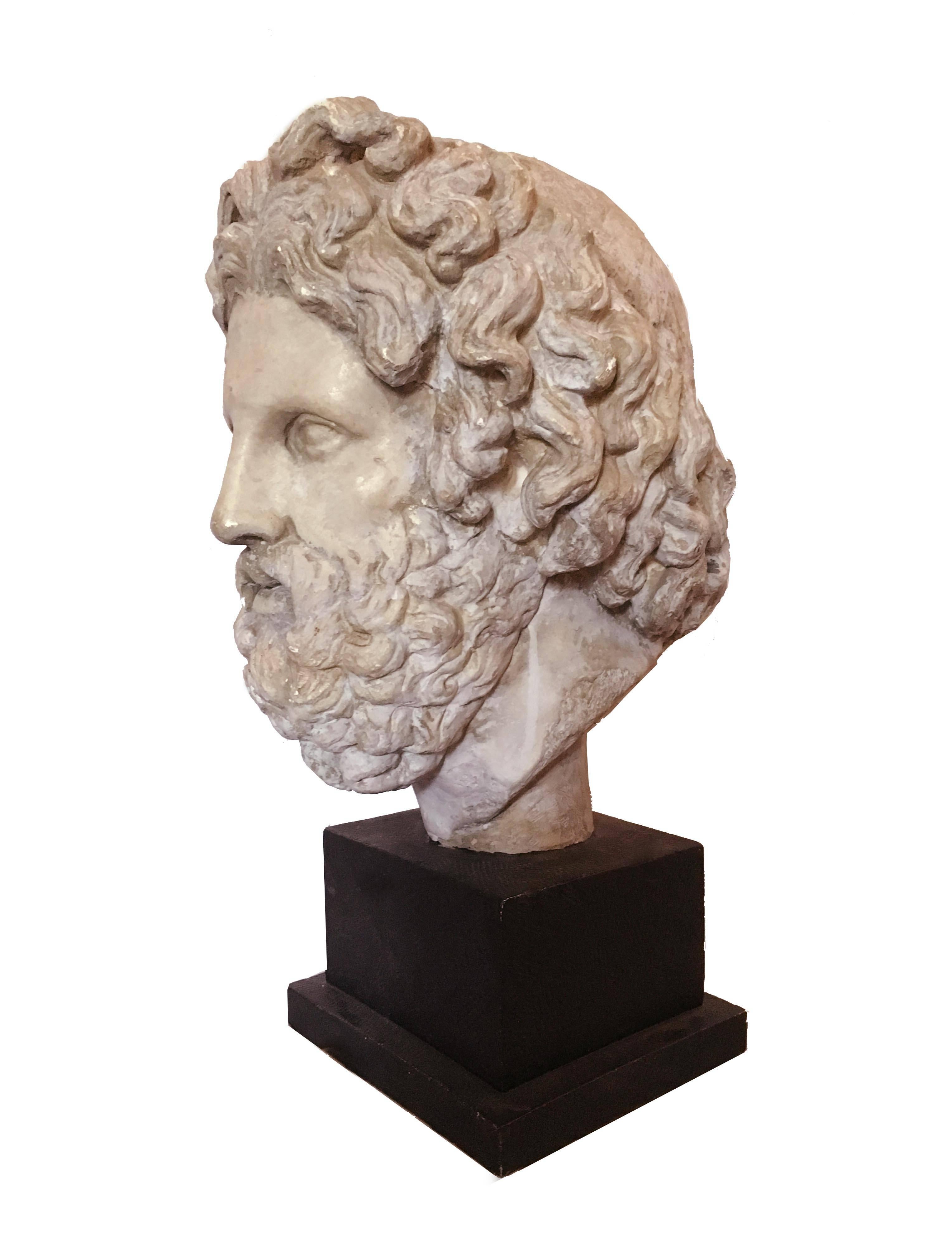 A museum reproduction of the fine monumental bust of Asklepios, Greek God of healing housed in the British Museum. The original, a part of a cult statue to the deity in Melos, Greece, dates from 325-300 BCE. Reproduced in fine patinated plaster on a
