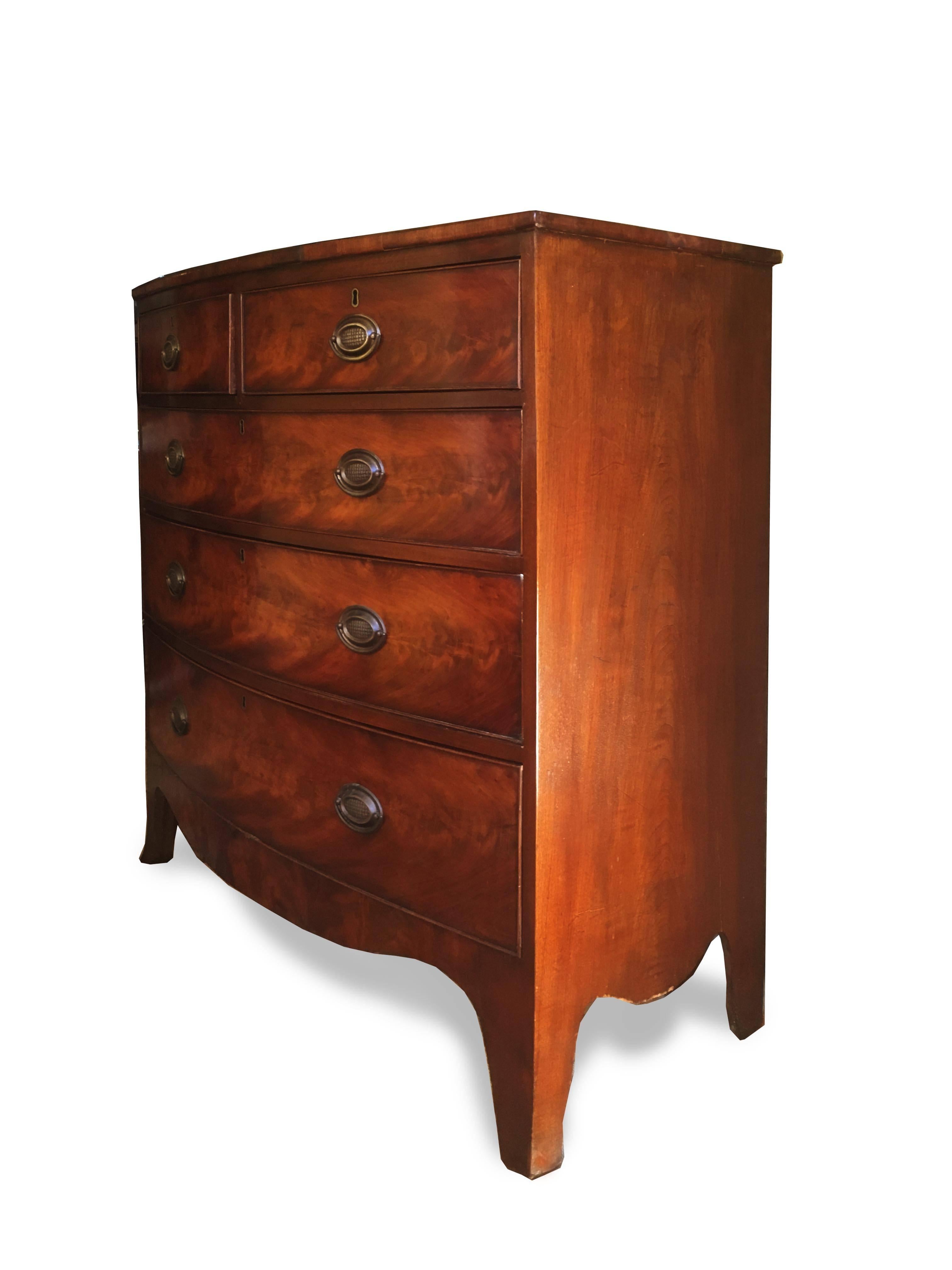 A stunning George III bow front mahogany dresser with three full length drawers and two smaller half drawers. The mahogany veneer is of exceptional quality and has mellowed to an attractive honey amber color. Oak and pine secondary woods. The