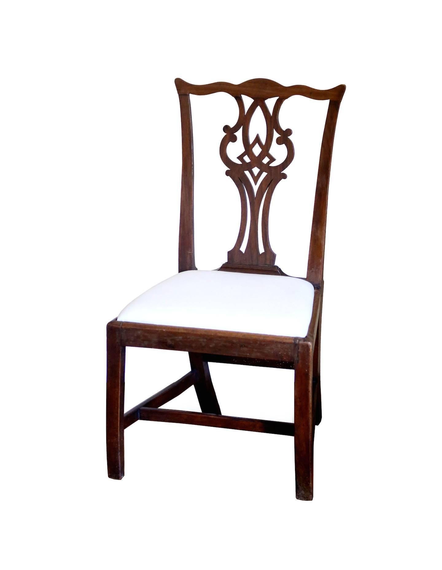 Two very attractive walnut chairs, with serpentine crest rail, square legs. The beautiful pierced backsplat features C curves and interlocking diamond. Rose head nails support corner brackets for the drop seats, which are presented in muslin