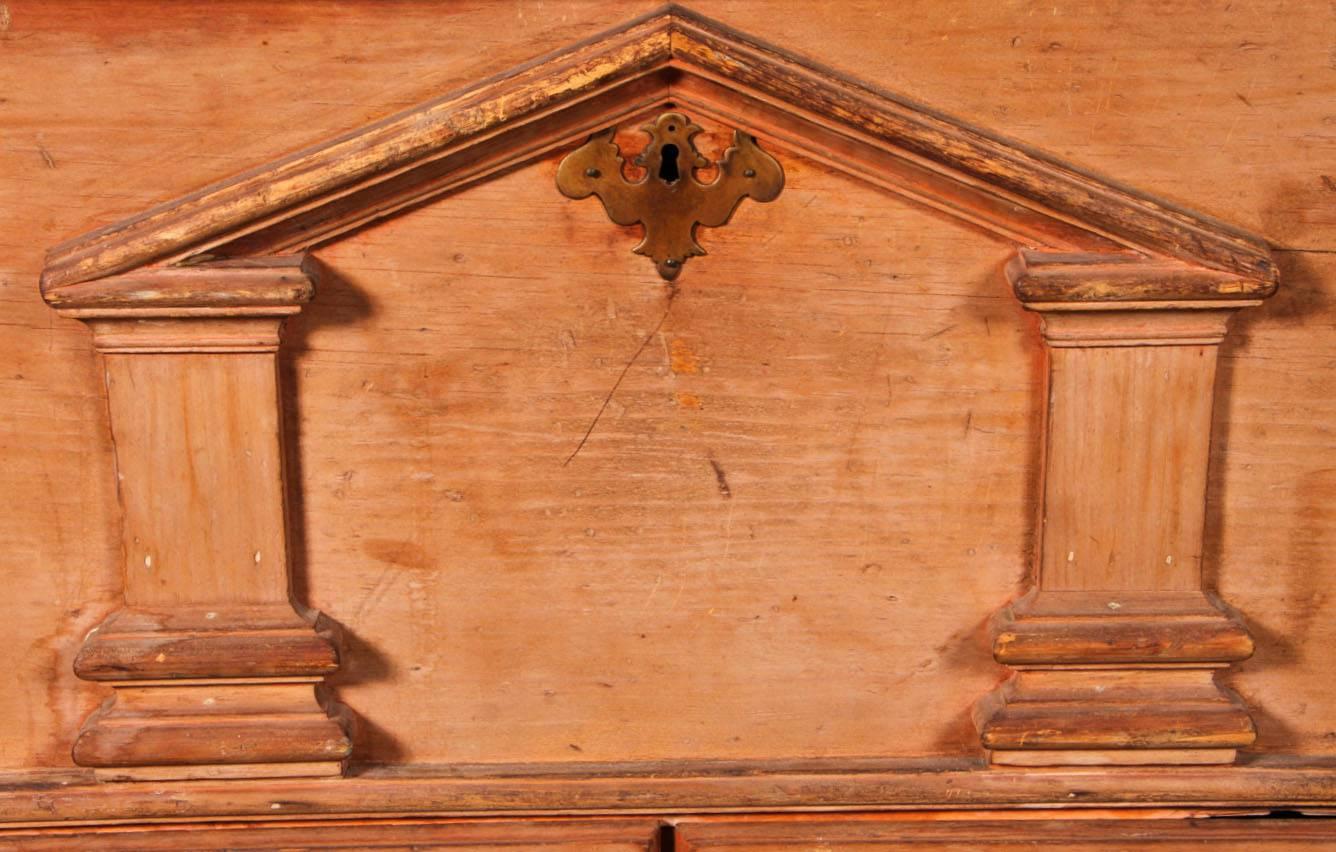 An exceptional and unique architectural chest from 18th century America. The chest rests on ogee bracket feet, and detailed pilasters with fluting and bases and capitals sit on top of a drawer section with canted and fluted corners. The central