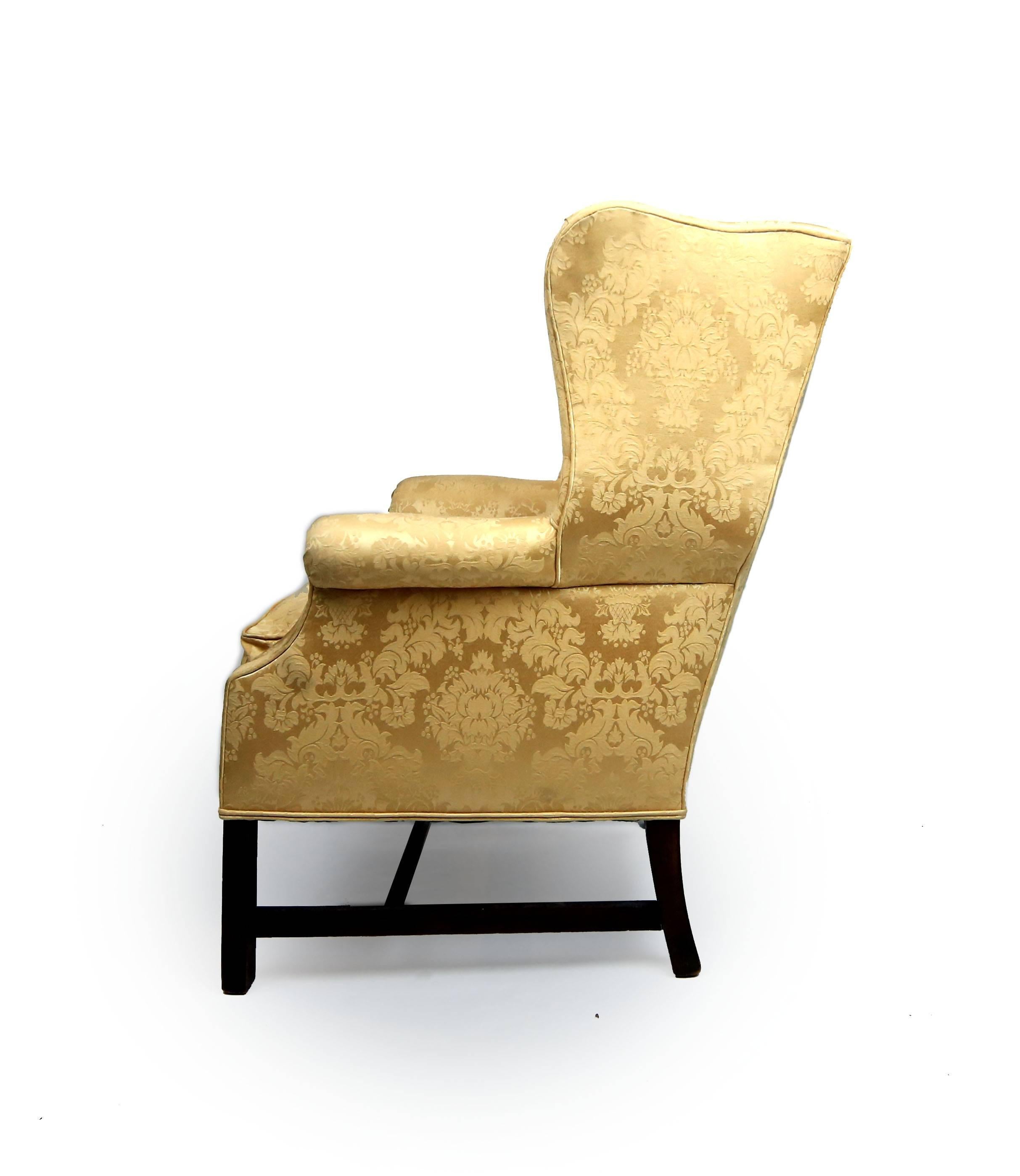 Well proportioned armchair with pleasing and curves supported by square molded legs. Feather cushioned seat and upholstered in gold damask. Possibly early 19th century.