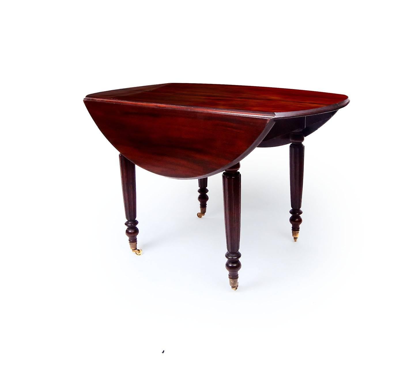 A rare, rich circular breakfast table or children's dining table in Cuban mahogany. Deep red lustre, the thick top boards have a molded edge. The base composed of tapering legs with reeded legs and spooled bases. France or England in the manner of