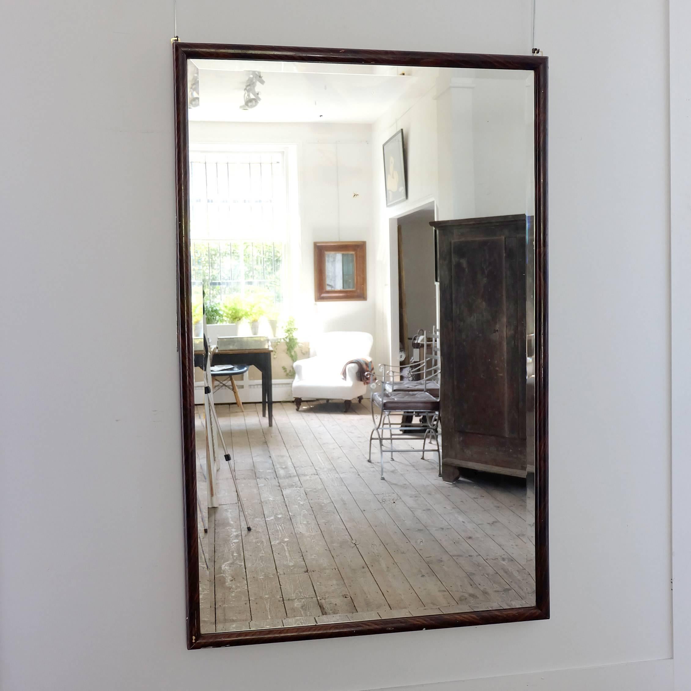 A huge beveled glass mid-20th Mirror with a simulated rosewood frame, the glass is showing a few signs of ageing aswell as the frame, but what a stunning piece.