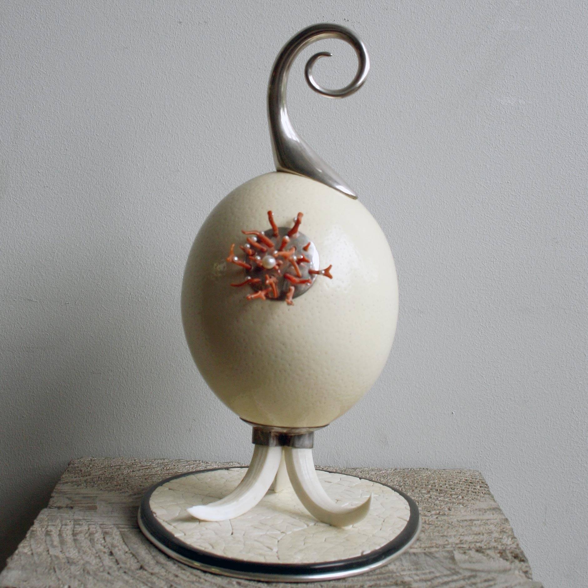 Sculpture en forme d'œuf d'autruche réalisée par Glyn Lockett, avec une tige en laiton argenté et une plaque appliquée avec du corail et des perles de rocaille sur une base en corne de buffle argentée, sertie de sections d'œufs d'autruche écrasés,