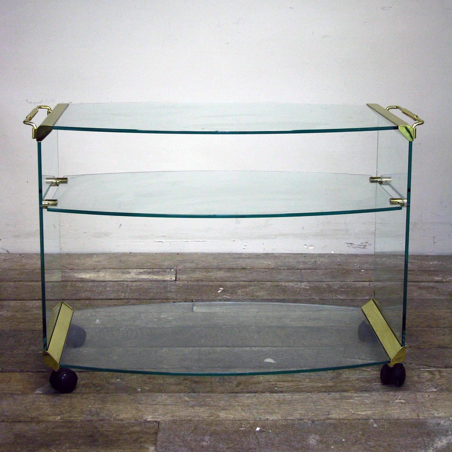 Magnificent Italian glass drinks trolley designed by Pierangelo Gallotti and produced by Gallotti & Radice during the 1980s.

The drinks trolly comes with thick tempered transparent glass and gold colored steel handles and edges.

 