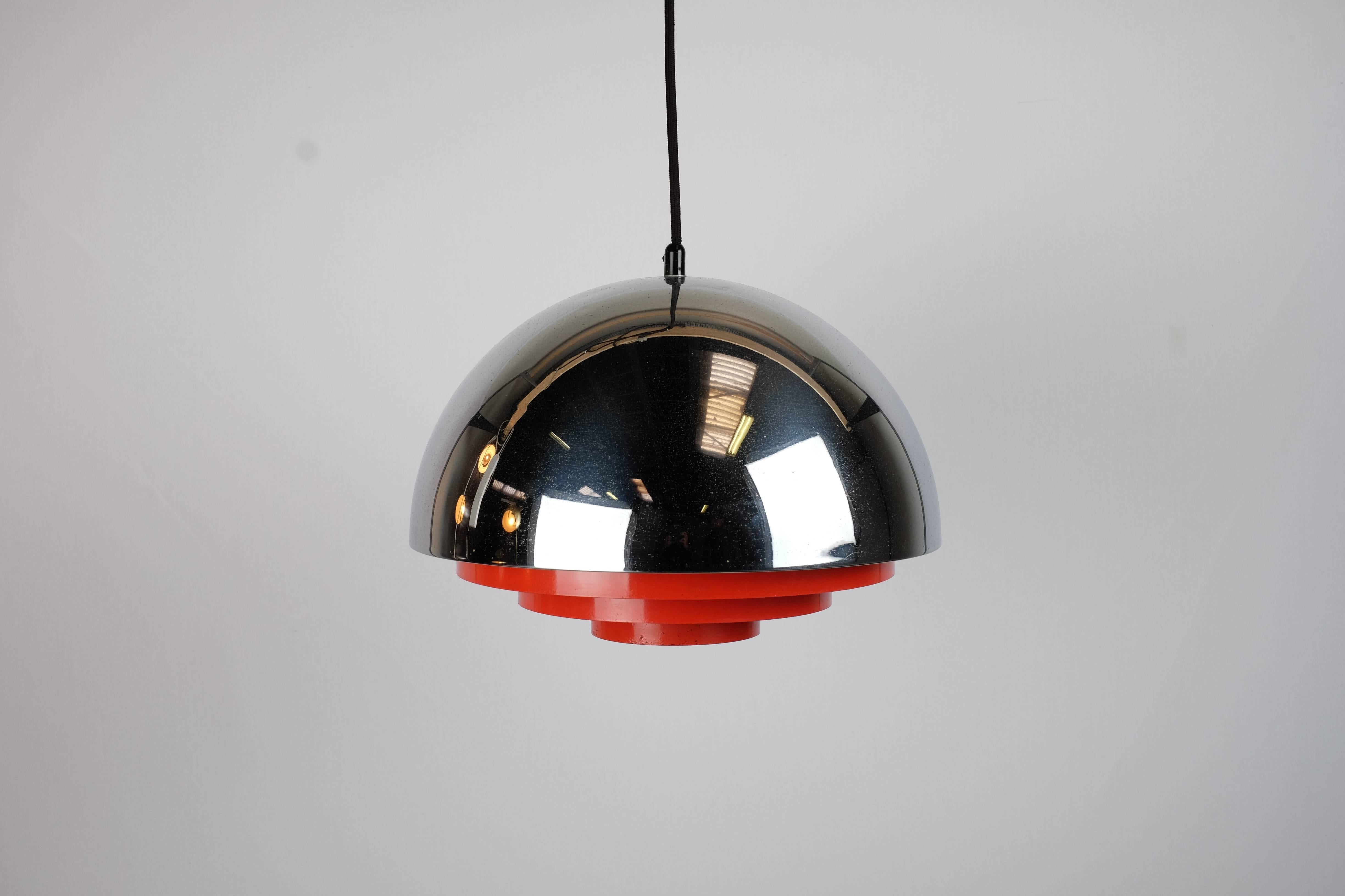 This rare model Milieu pendant lamp was designed by Jo Hammerborg in the early 1960s and manufactured by Fog & Morup in Denmark. 

The lamp is made from chrome with red metal slats and features a glare-free light. 

The lamp is fully