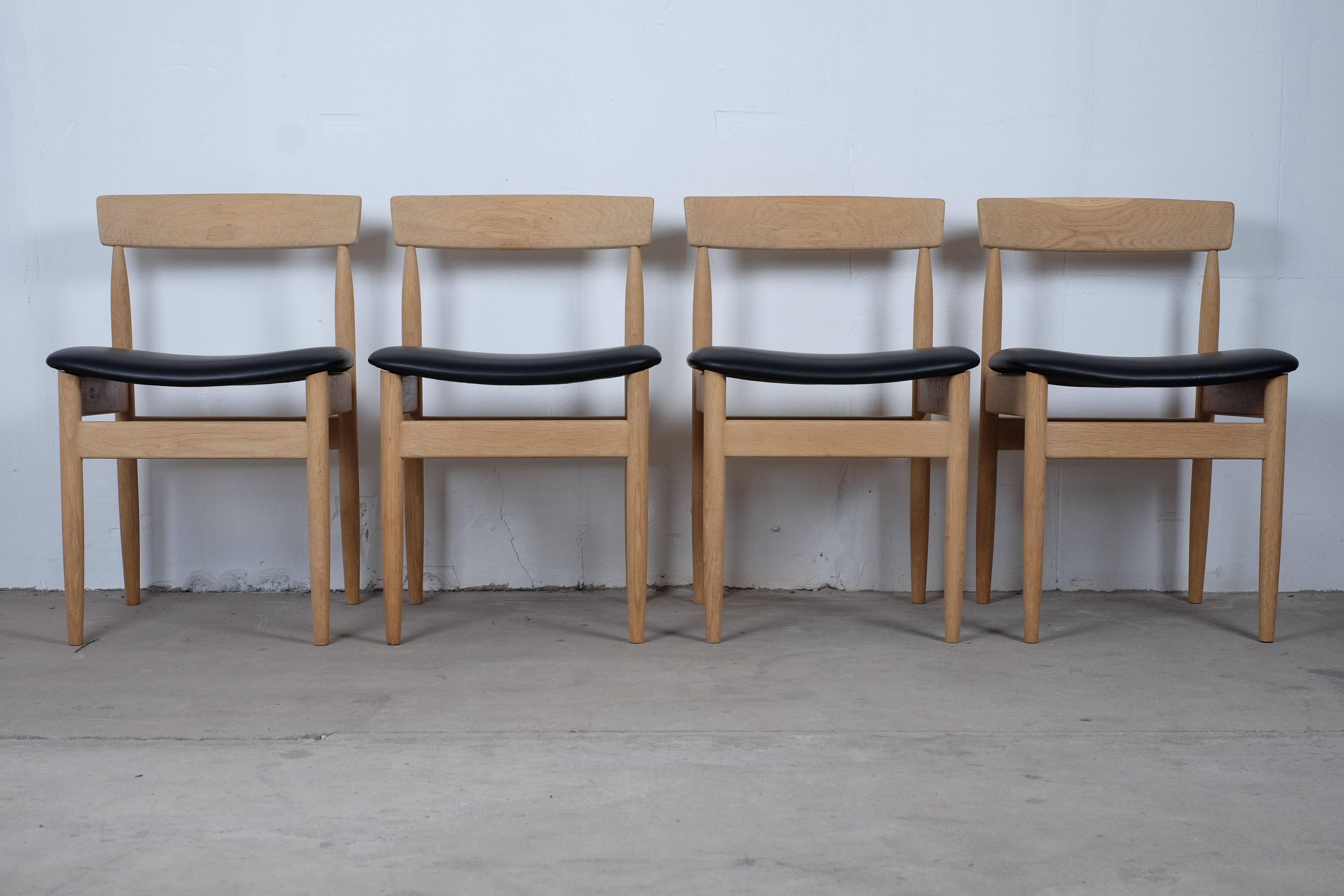 Beautiful set of four vintage dining chairs in solid oak, reupholstered with black leather. The chairs is furniture controlled and 'Made in Denmark' stamp but I haven't been able to find the designer of this chair. 

The chairs has been to the