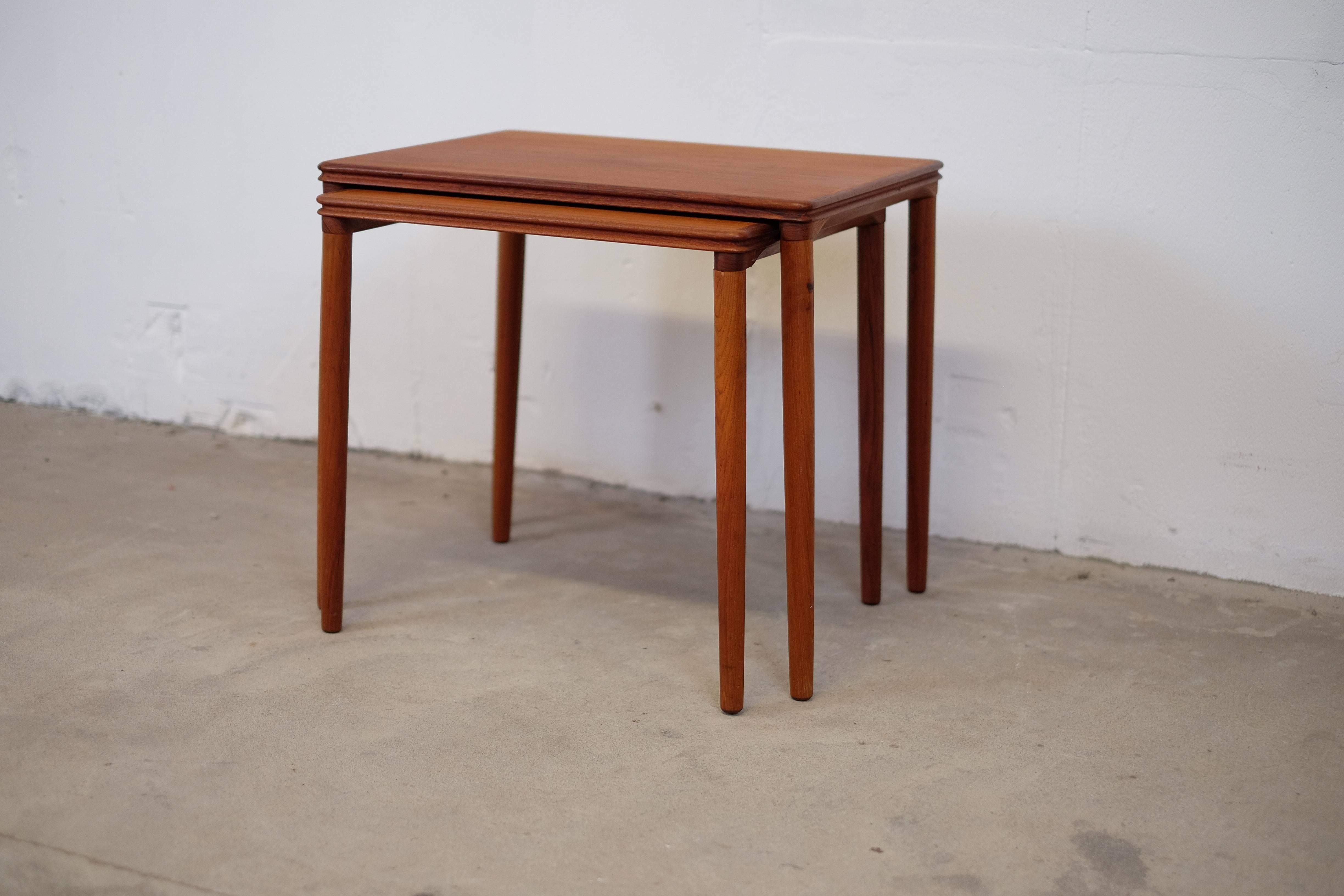 Pair of two nesting tables in teak wood with inclined legs and some beautiful details. 

Great Danish craftsmanship from the 1960s era. 

Both of the tables is in good condition.

Small table: H: 46cm B: 47.5cm D: 40cm 
Feel free to ask if you got