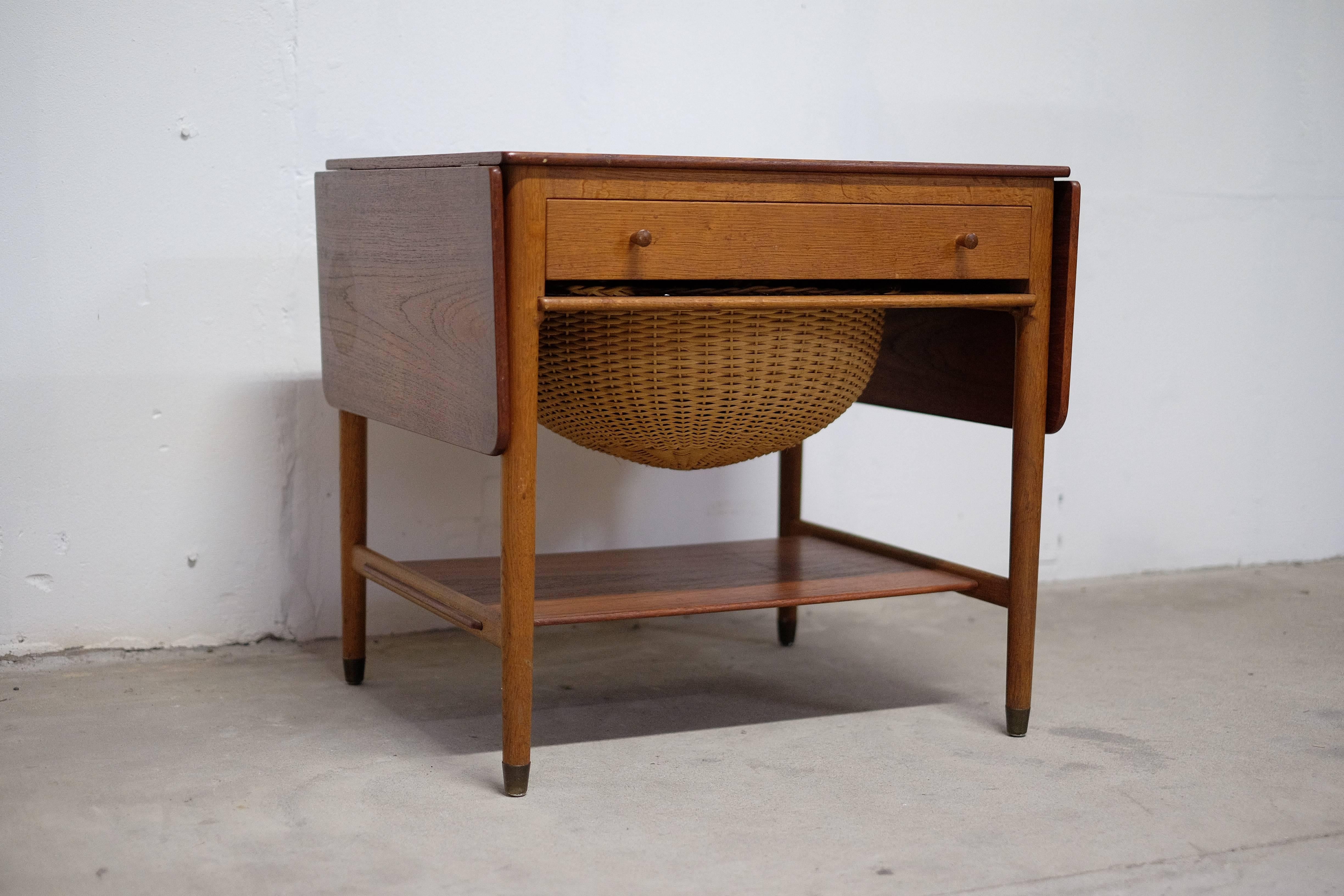 Hans J. Wegner sewing table. Model: AT-33. Design 1959. Solid teak and wicker.

The table is in good condition with few traces of age-related use. It has a spot on top.
If you like to receive the table, sanded, polished and shined up to look as