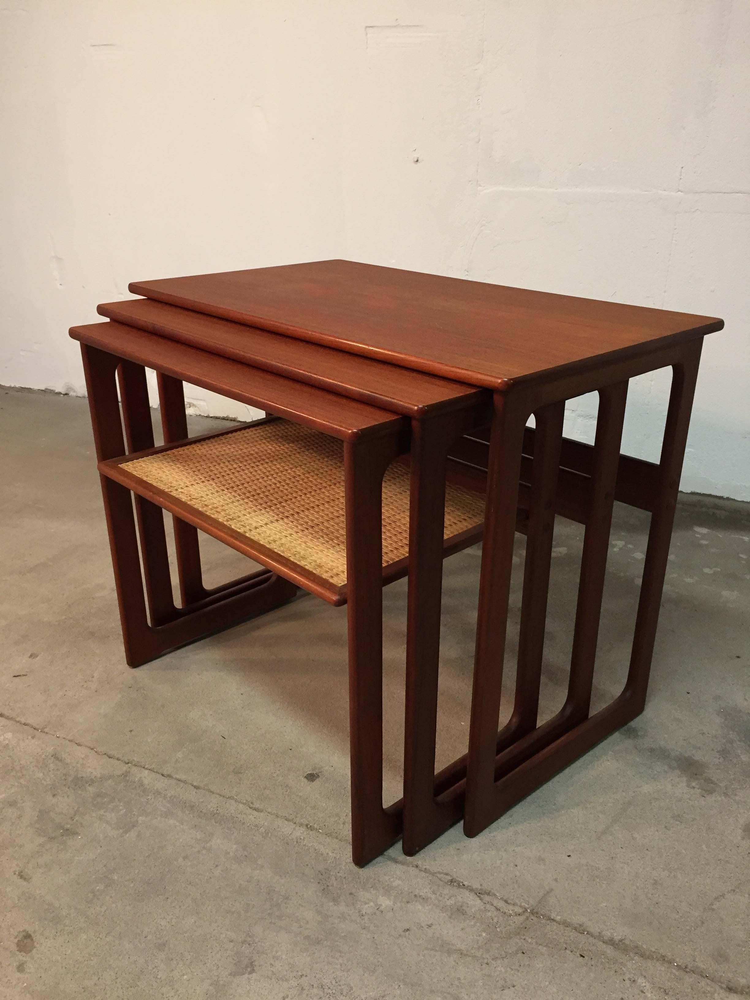 Danish Mid-Century set of three nesting tables in teak with cane shelves. 

Designed by Johannes Andersen and Illum Wikkelsø for manufacturer CFC Silkeborg. 

This tables are in very good condition, newly renovated and oiled. 

Dimensions:
H