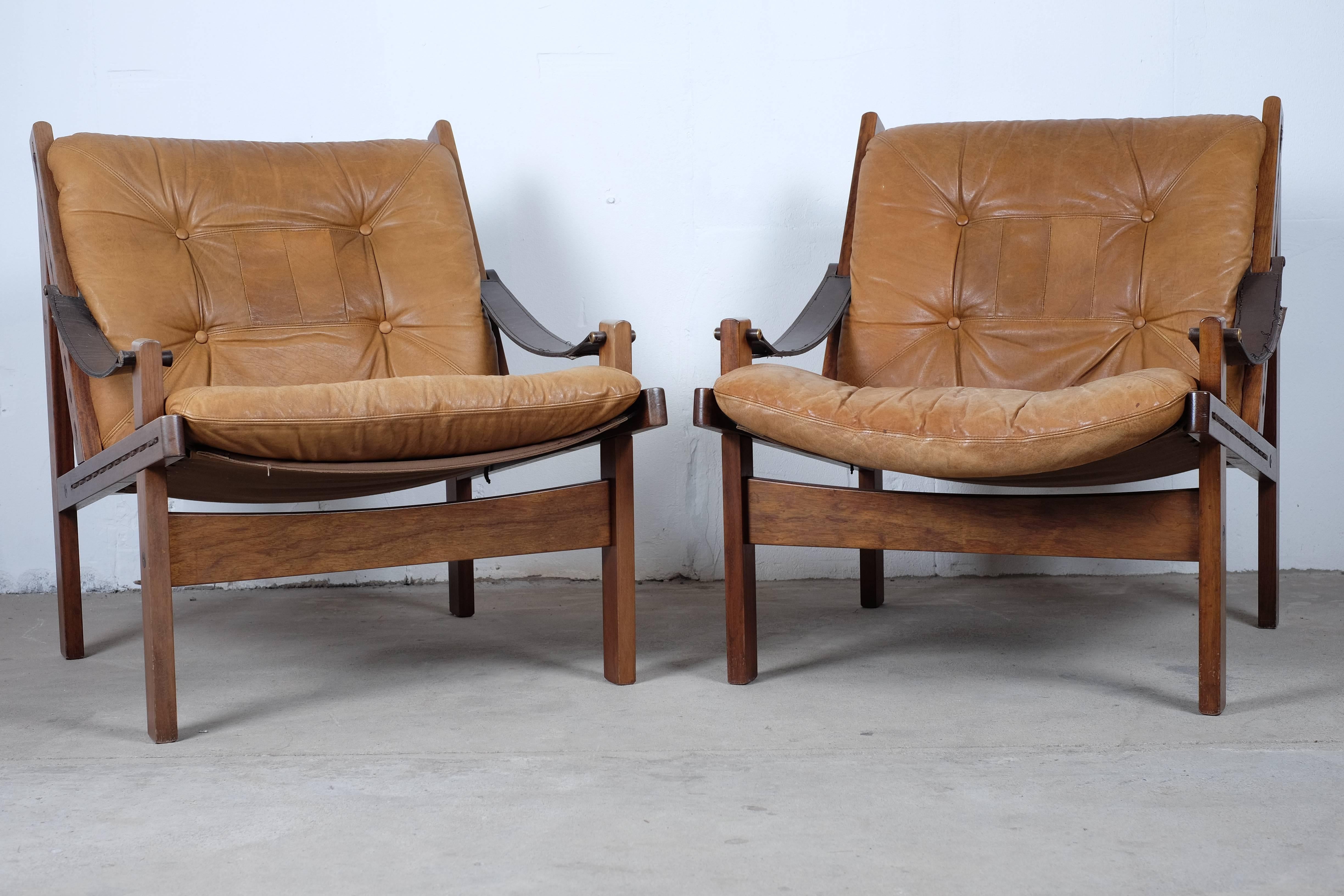 A matching set of three easy chairs two low back and one with high back, brown leather Hunter chairs designed by Torbjørn Afdal and manufactured by Bruksbo, Norway.

These Hunter chairs are constructed from stained solid oak frames. 
The frames