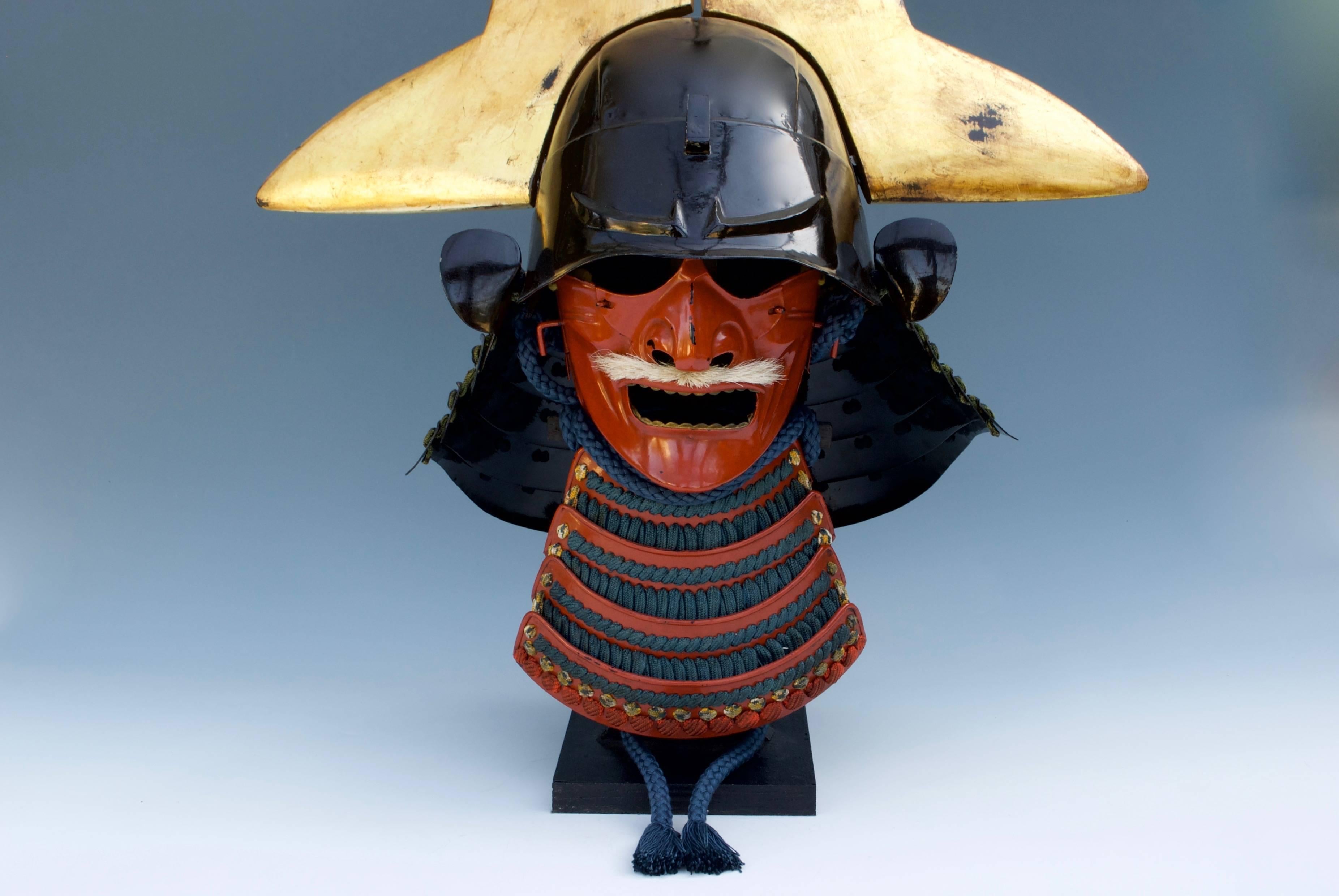 A Japanese iron lacquered Kawari Zunari Kabuto. Large golden wood Wakidate to simulate the top of an arrow. Iron and red lacquered Menpo of 20th century.