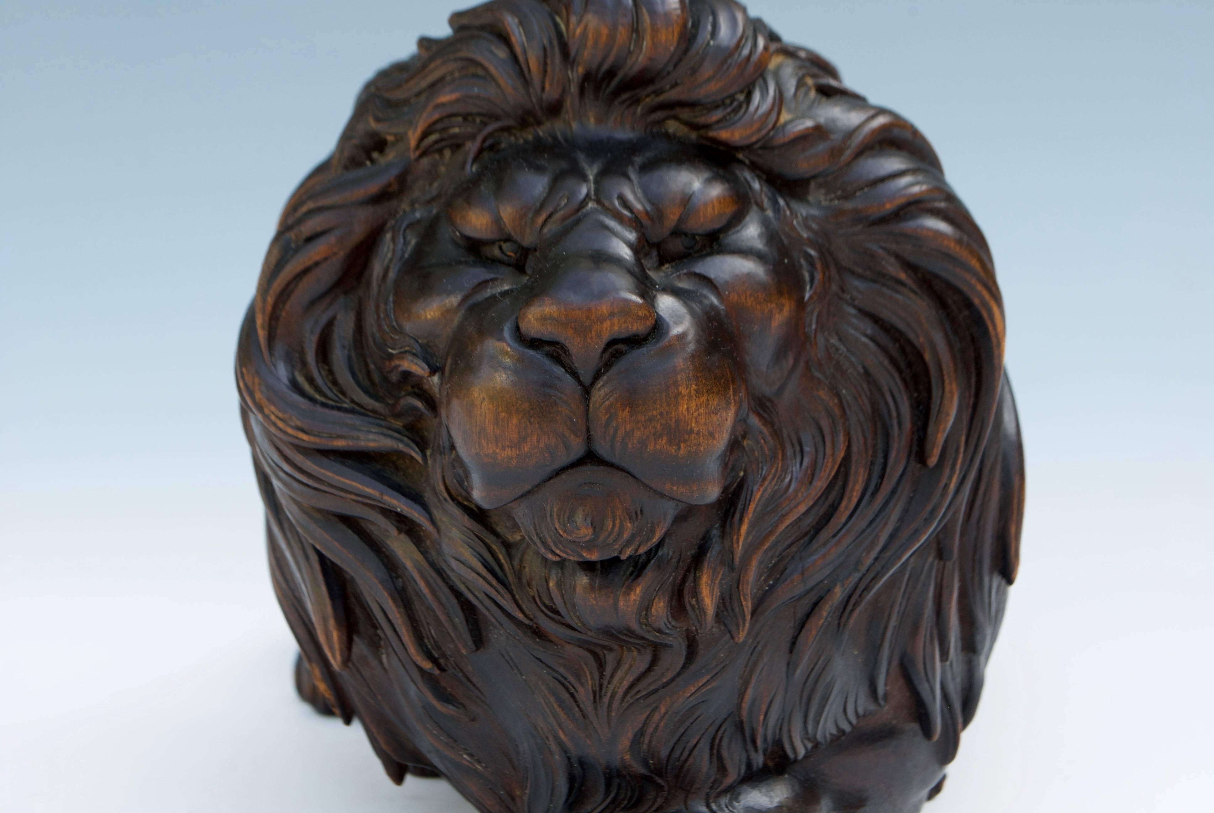 A Japanese carved wood sculpture okimono of an elegant and mightily lion with thick mane. Good patina.