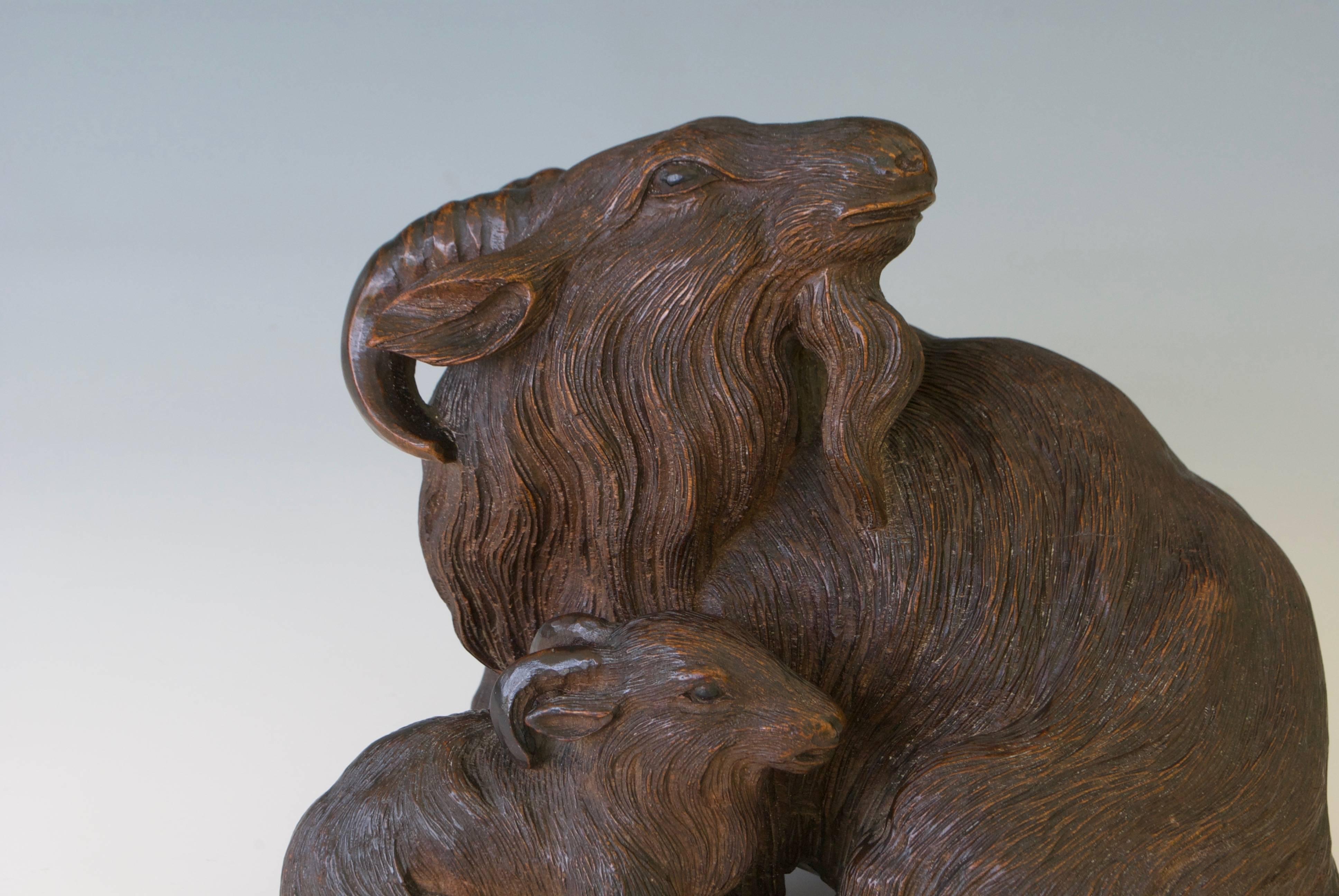 A Japanese wood okimono of a goat with kid. Signed under the base on a rectangular reserve.
