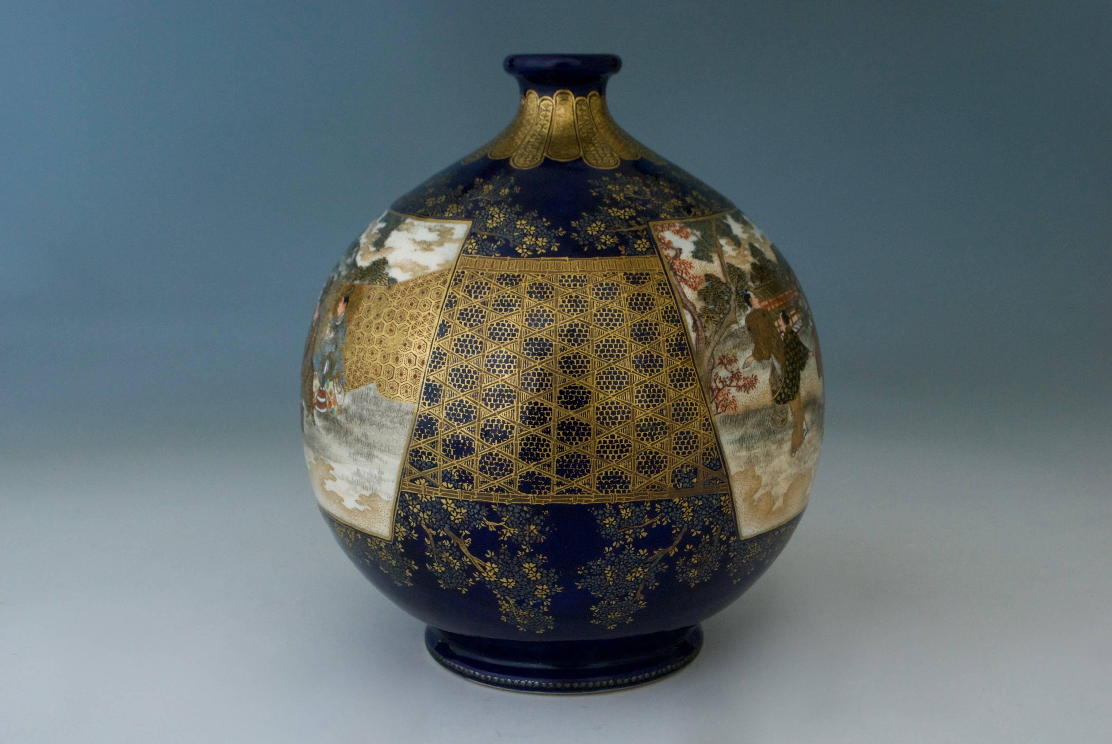 A Japanese globular shape Satsuma vase with two panels, one featuring Japanese people dancing in a landscape, the other of some samurai watching them, all reserved on a dark cobalt blue ground enriched with silver and gilt flowers and honeycomb