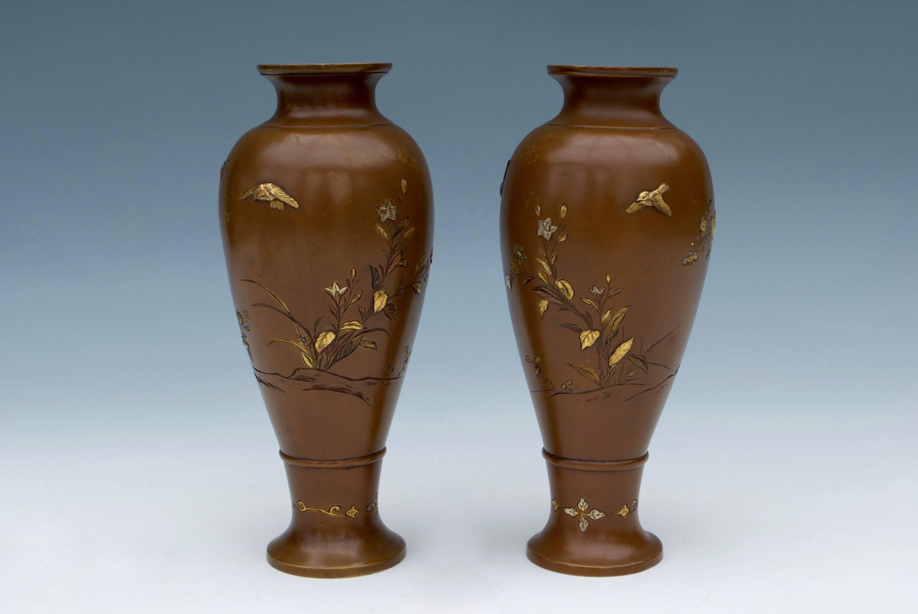 Elegant pair of finely bronze vases decorated with floral motifs with gold and silver inlay applications. Hatayama signature under the base.
