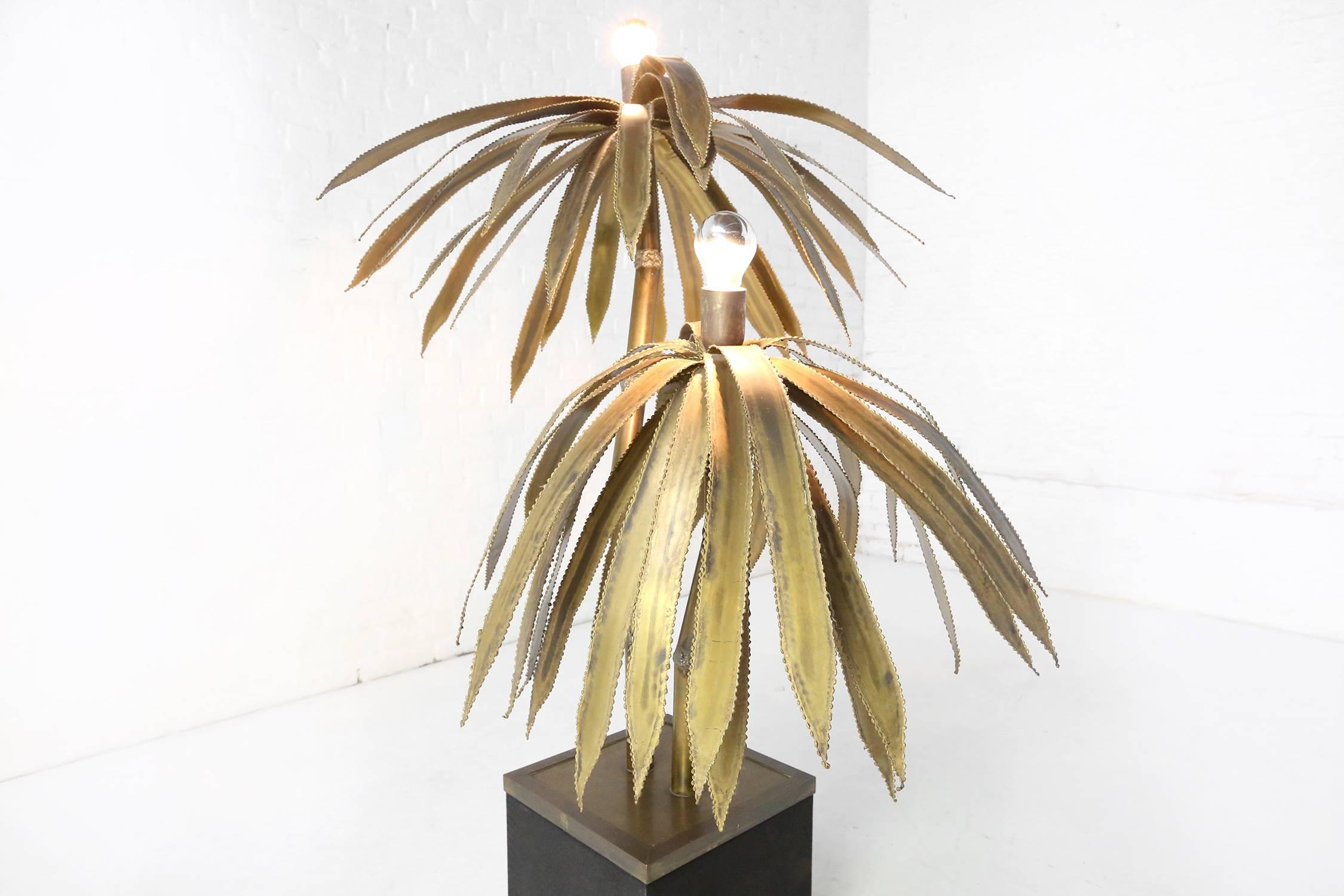 Brass Maison Jansen palm tree lamp, with two brass palm tree stems with a light on top of each.
Mounted on a felt covered base with bronze edging.
Rewired with black antique cord flex and switch.
Base measures 26cm x 26cm x 26cm.