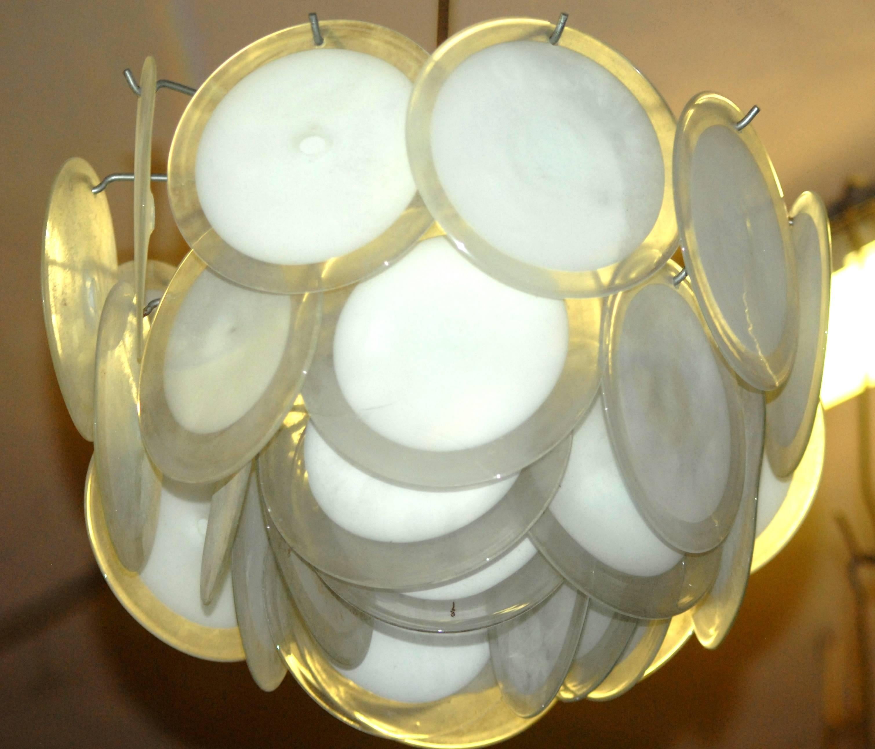 Directly from Alfredo Rossi. Each chandelier carries over 30 discs made with the rullati technique. The same technique is used to make Renaissance windows. White glass Sommerso with clear glass, and then hand opened and flattened. Pontil mark still