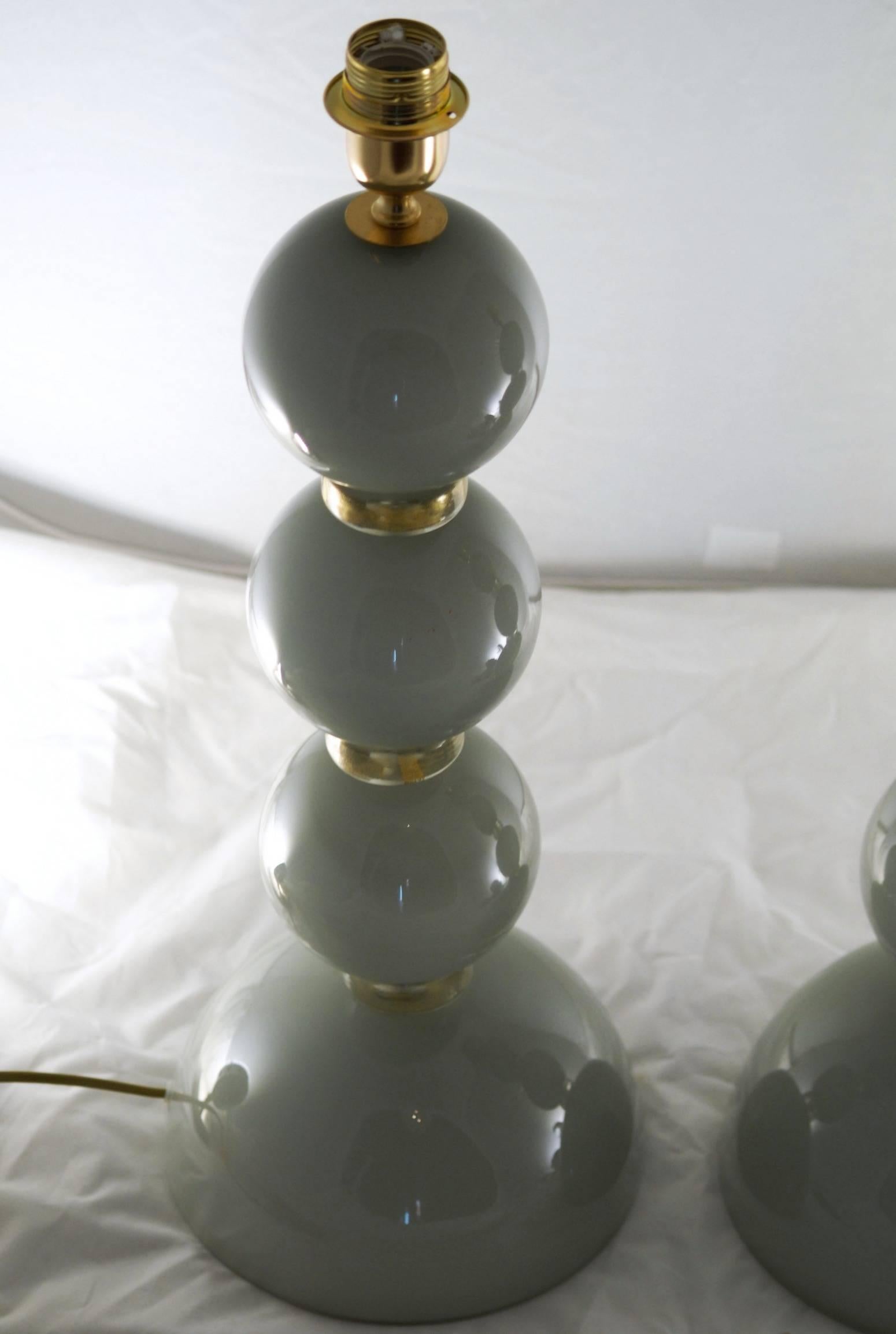 Pair of tall table lamps from Alberto Donà in Murano. Unique color created casing gray acciaio over lattimo solid white color. Lamps are made of stacked plain spheres in gray. The color is the result of incamiciato, casing steel gray over lattimo,