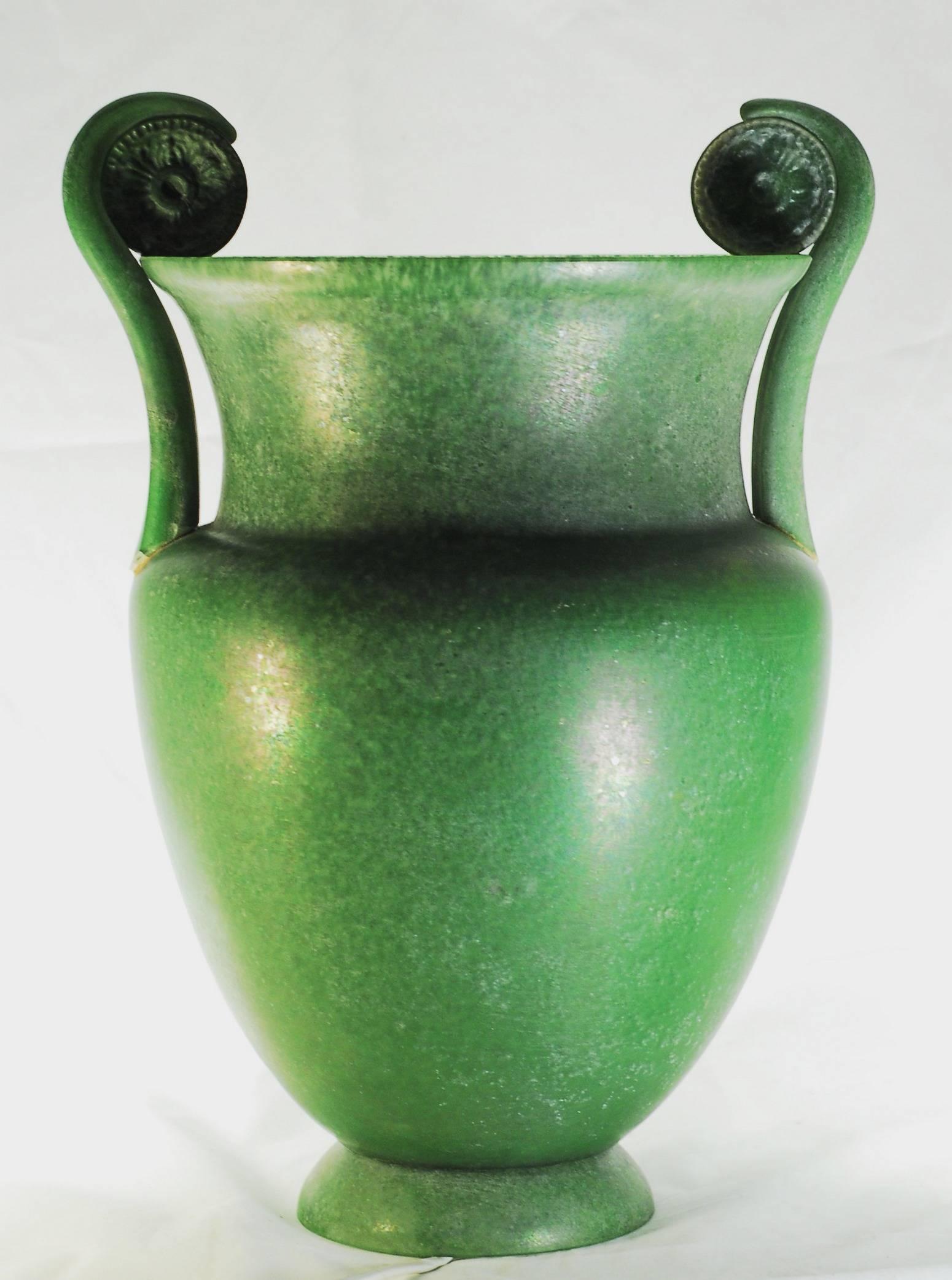 Monumental glass crater vase reproduction by Sergio Rossi, late 1980s. Scavo and green. Torchere.

This is the tall vase part of the Athena group, made as a table torchere. The green coloration is made with “mace”, rolling the melted glass over