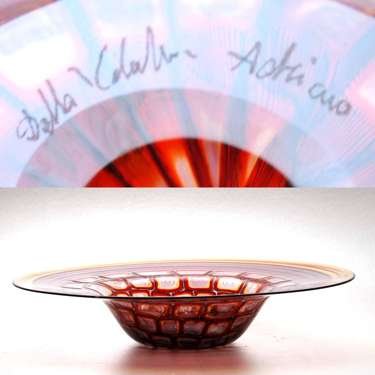 Here a beautiful bowl signed by Adriano dalla Valentina, Muranese master specialized in self made murrinas objects and sculptures. The bowl lip has two bands of amber and amethyst with a striking central part paved with murrinas. These are made with