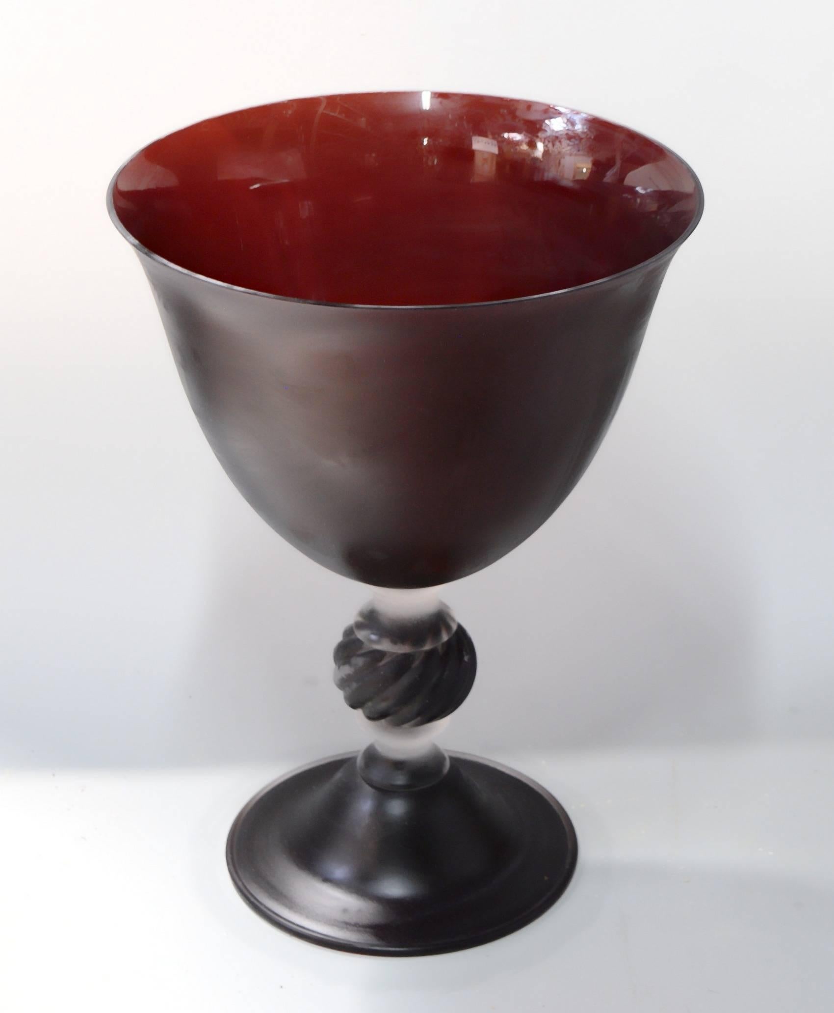 Grand footed vase from the 1980s, has a magnificent carmine burnt red or deep topaz color that looks almost black from distance. 

A fantastic piece to dress a modern entrance or a living room.

Identification and evaluation: The color is the
