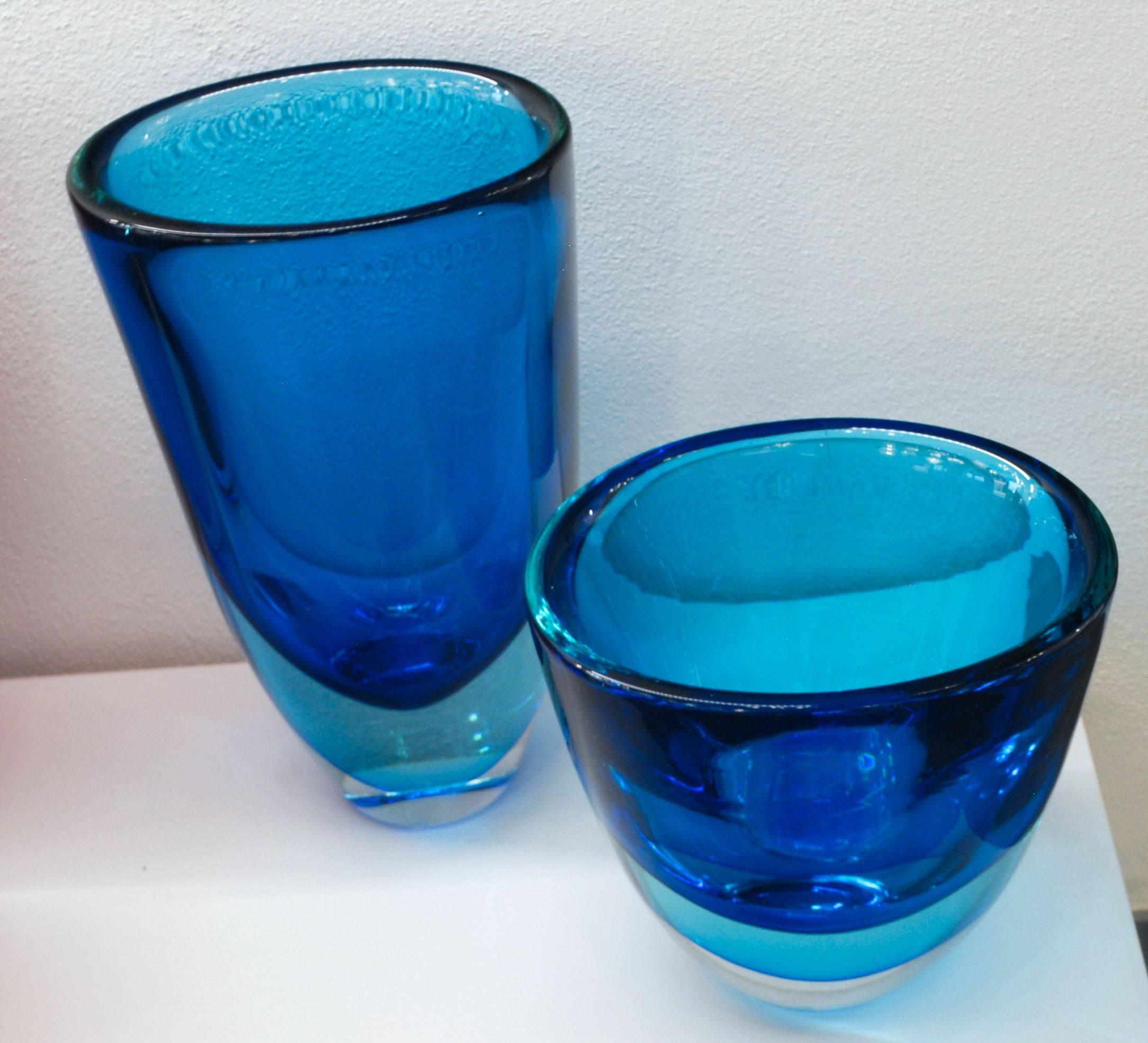 Two aquamarine and cobalt heavy and massif vessels from Stefano Toso. Shape is slightly squashed so has an oval mouth.

A colorful couple of vessel in a fashionable color. To be placed close to a window to catch the light.

There is a taller