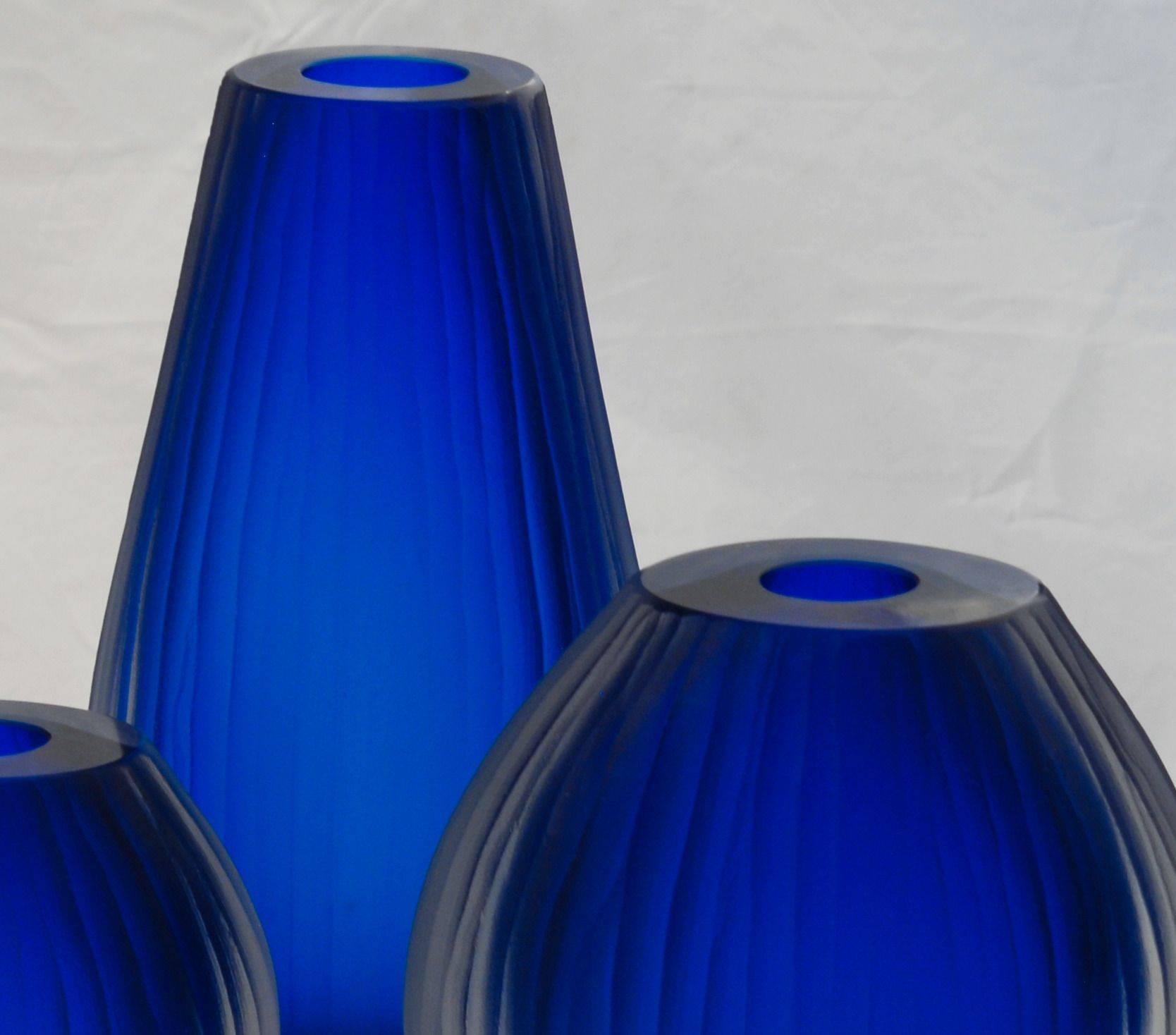 Here a beautiful cluster of three Sommerso vase. The inner color is a deep aquamarine, probably the color used for sbruffi, almost a cobalt blue. The outer glass is a massiccio clear. Each vase is completely finished in battuto.
The play of light