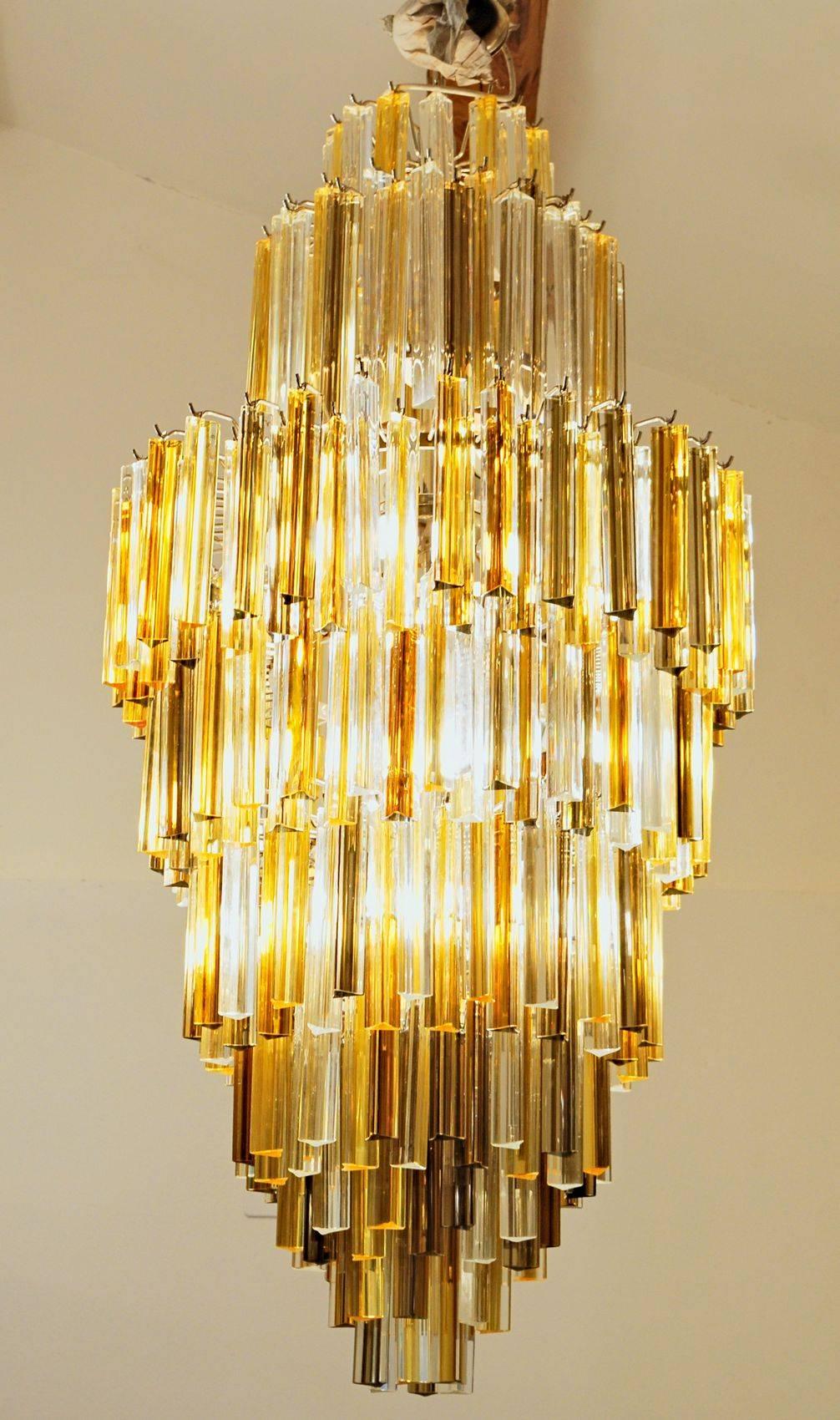 This chandelier has 342 elements of triedri elements. There is a combination of clear, amber and deep amber triedri. The mix gives a sculptural art dimension to this mid-century modern chandelier.

The polished ends are creating a remarkable effect.