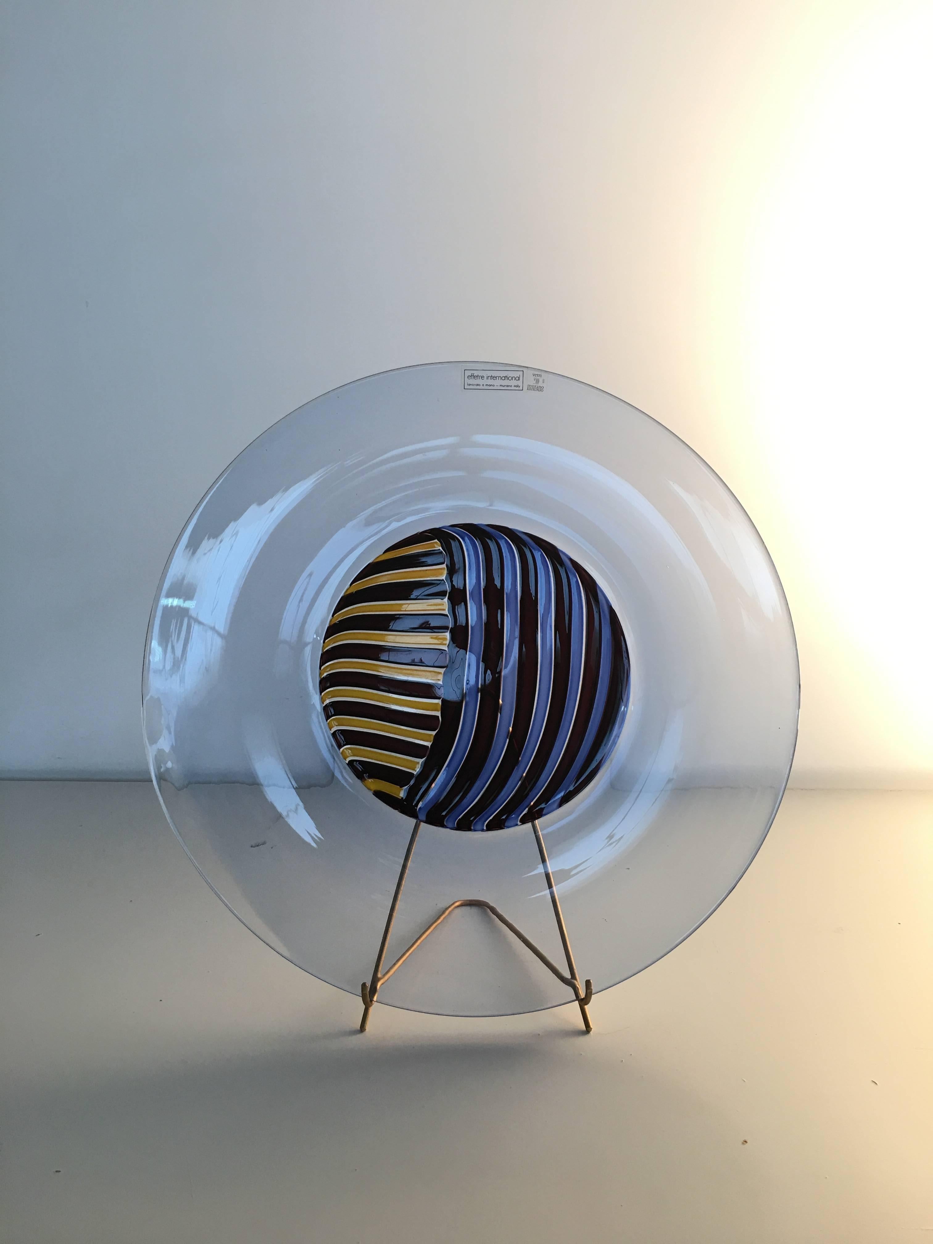 Attributed to Lino Tagliapietra: charger with stand. 1990s production from Effetre. Clear bluino incalmo with piera cane central design. Collector's piece.

Charger/plate, hand opened with central part made up of two-tone piera canes and incalmo