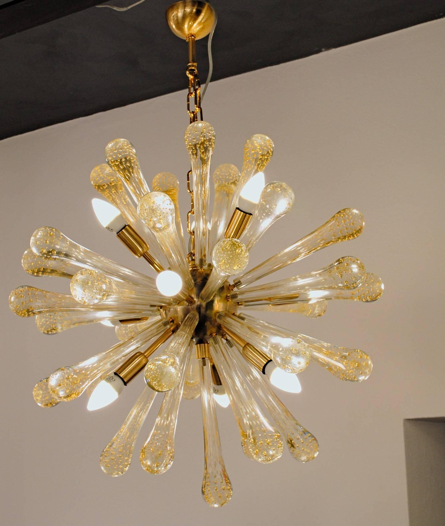 Teardrop shaped glass elements with Baloton finish and pure gold leaf. 
The mix of lens effect made by the bubbles and warm mirror reflection made by the gold speckling creates a beautiful play with light.

Midcentury Sputnik chandelier. Murano
