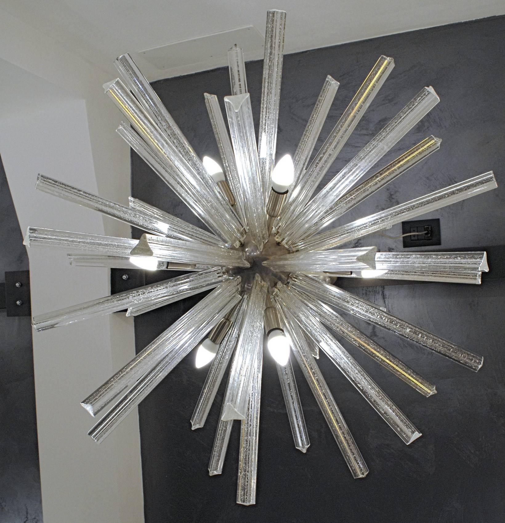 Compact and graceful midcentury style Sputnik chandelier. Murano glass hand-pulled triedri rods that are rolled over silver leaf. When pulling the shaped glass the silver leaf breaks in speckling that are making a beautiful play with light.

Made