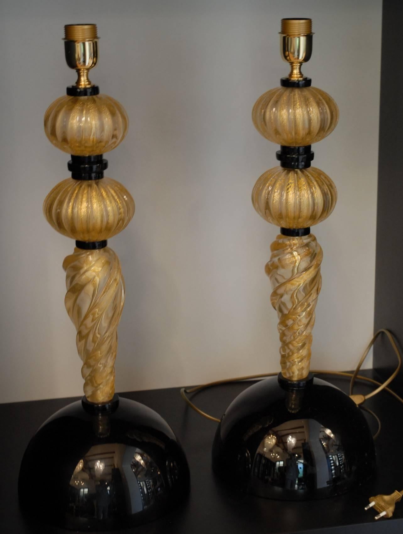 Two splendid deco style Murano table lamps. There are two kind of glass elements stacked to build this beautiful table lamp. The 24-karat gold leaf embedded elements with rigadin, straight on the pebble looking parts and twisted on the longer part.