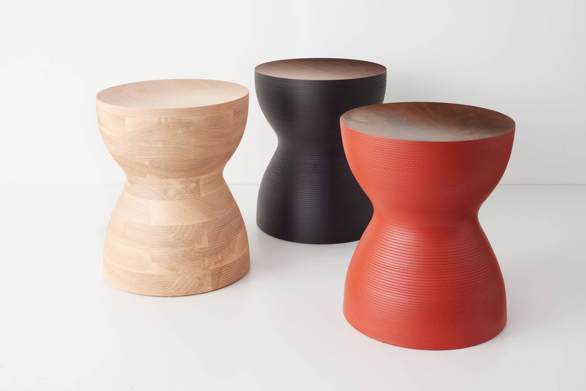 Stacked lamination of ash hardwood with a maple top, turned on a lathe. This pleasing sculptural object can be used as a side table or stool for seating. They look great in this natural finish or in colors - blue, red, or black. They are made of